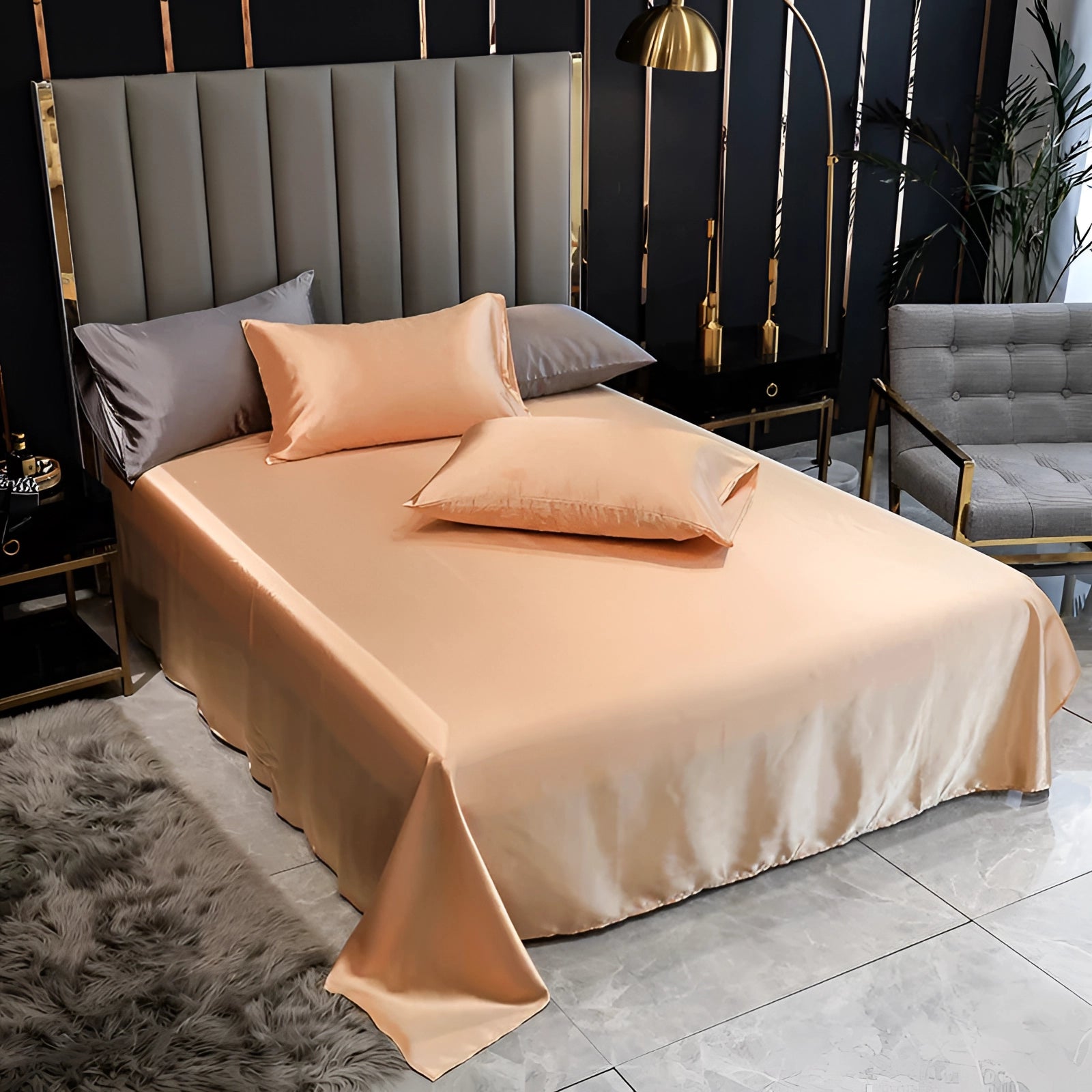 Luxury black silk bedding set with elegant satin bed sheets and duvet cover in peach color, displayed on a bed with a wooden frame in a well-designed interior space with hardwood flooring.