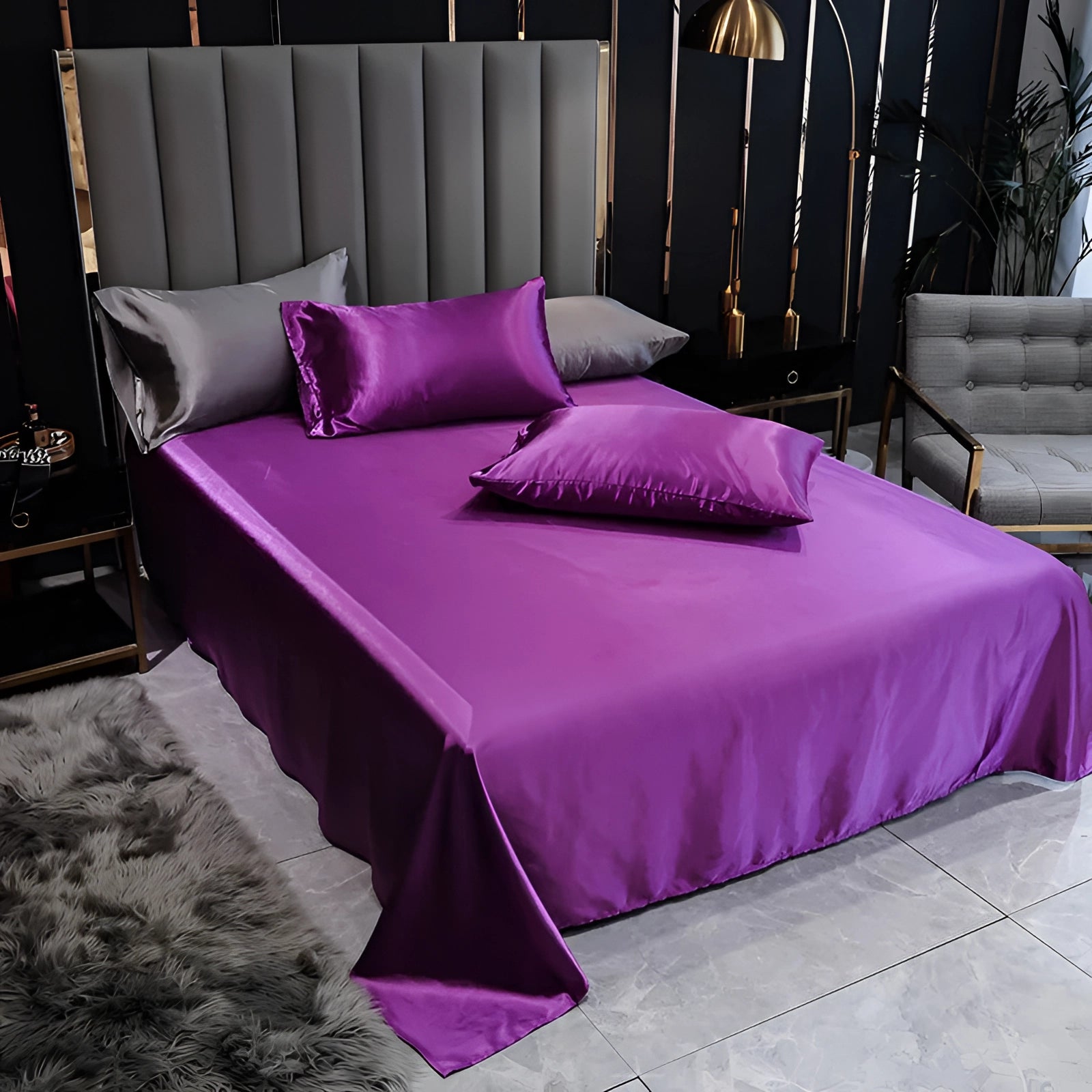 Luxurious purple silk bedding set displayed on a well-made bed, showcasing elegant satin bed sheets and a duvet cover in a spacious bedroom with tasteful interior design elements.