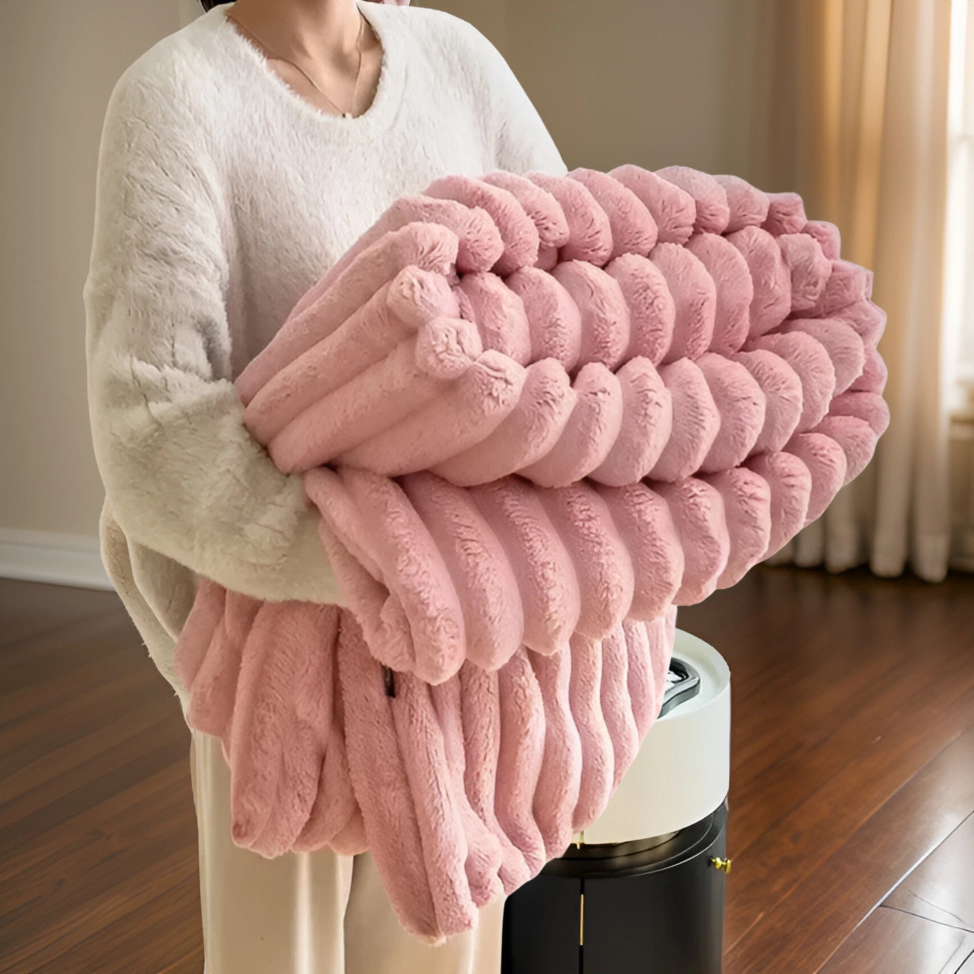 A soft, luxurious chunky knit blanket in a pink hue, draped over a human shoulder, showcasing its plush and cozy texture, suitable for modern home decor.