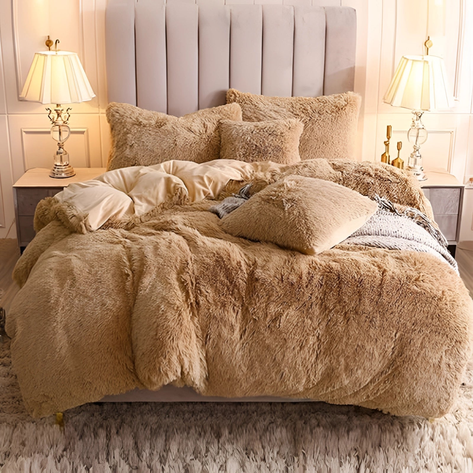 Luxury dark grey faux fur bedding set with soft plush comforter and shams in a superking size displayed on a bed. The room features a brown color theme with wooden furniture and a cozy interior design, including a couch, lamp, and warm lighting, creating an inviting and comfortable atmosphere.