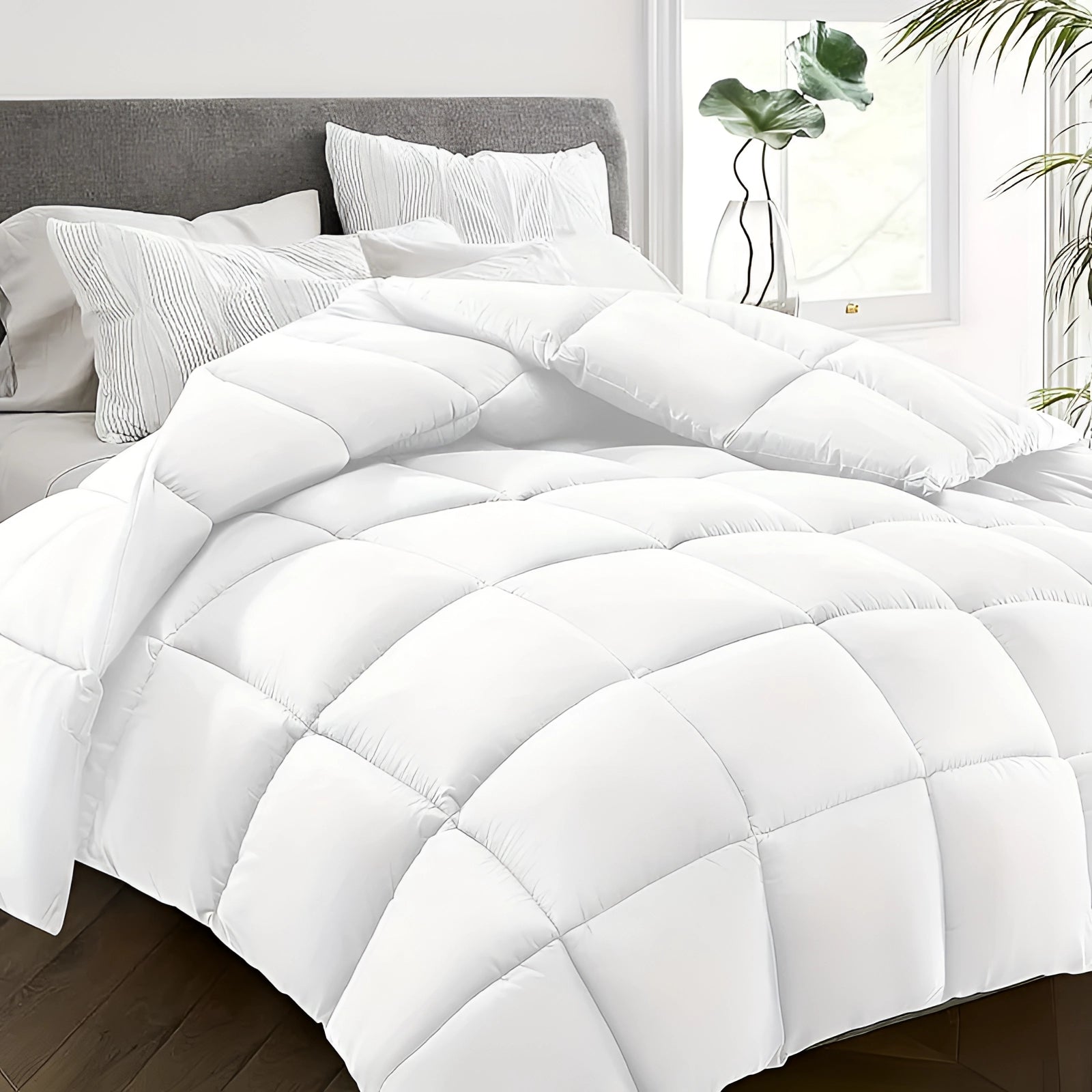 Luxurious dark grey hypoallergenic down alternative comforter in white color, measuring 229 x 269 cm, displayed with a textured pattern. The comforter is draped over a bed, surrounded by soft lighting and subtle decorative plants, highlighting its plush textile and comfortable design.