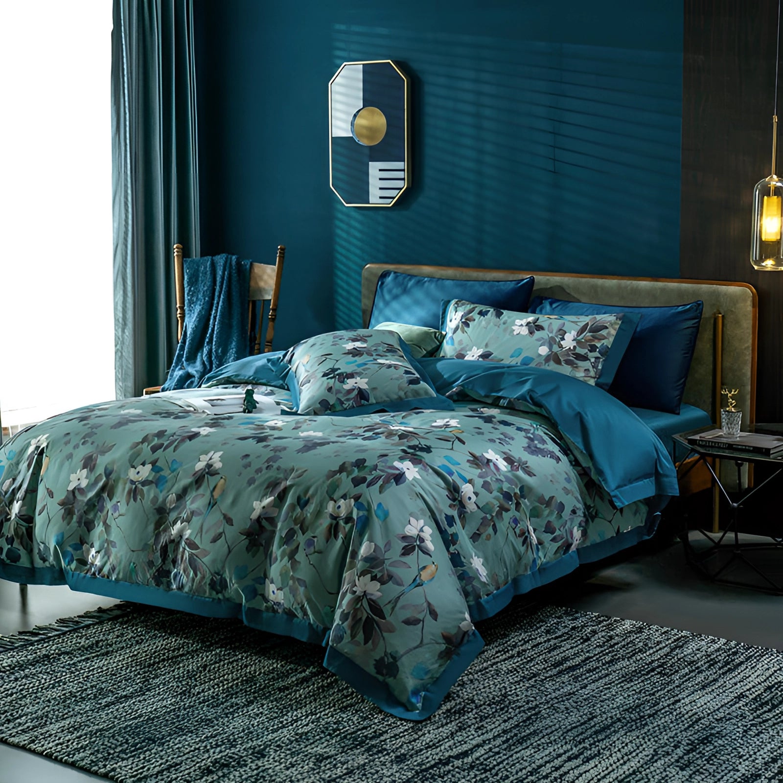 Luxury floral bedding set in deep blue, featuring designer botanical sheets and silk pillowcases on a king-sized bed, with a wooden bed frame and coordinated interior design elements.