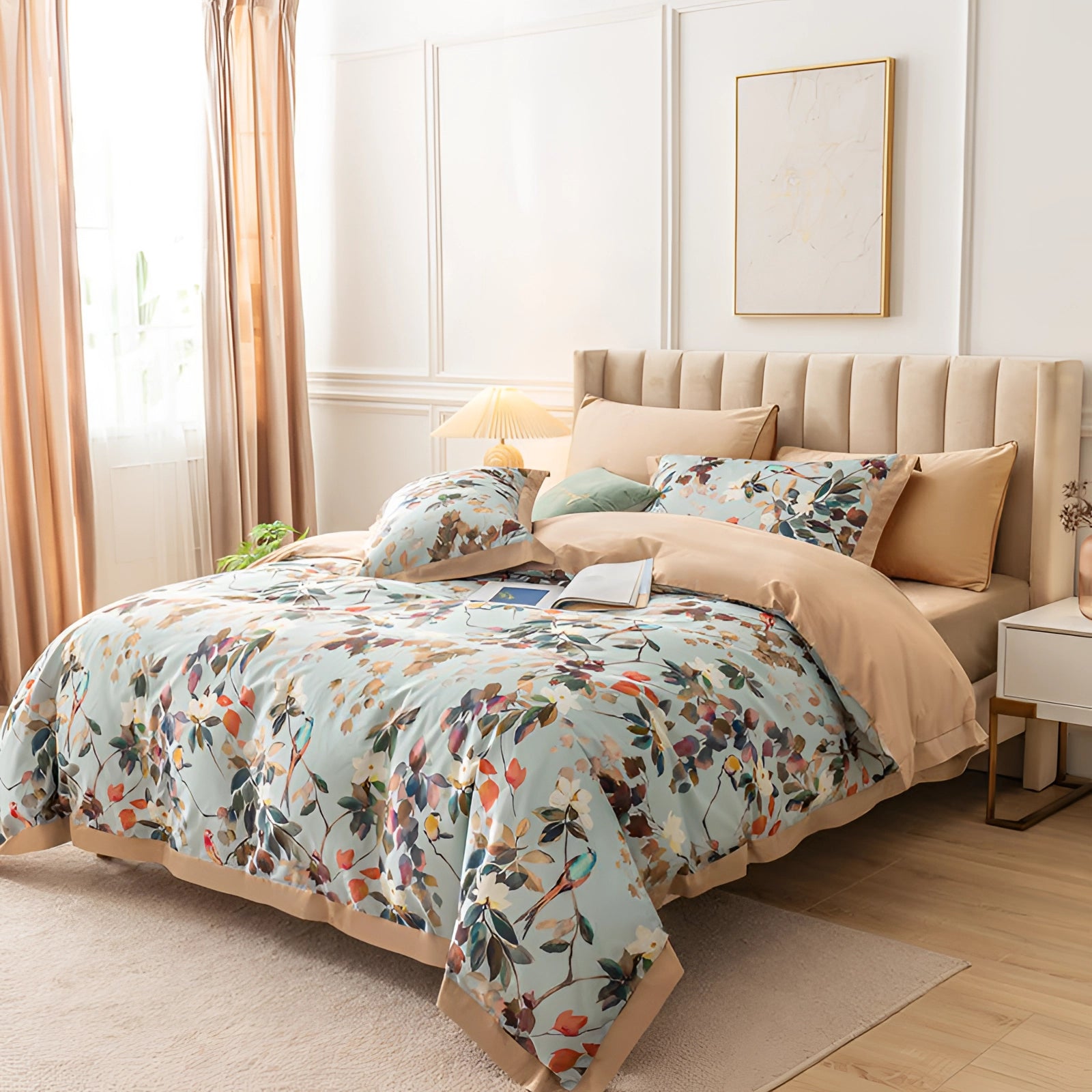 Luxury floral bedding set featuring a designer botanical print with azure accents. Includes silk pillowcases on a neatly arranged bed within a stylishly furnished room, showcasing a blend of comfort and elegance. The setting highlights interior design elements such as wood flooring and a window, enhancing the tranquil ambiance.