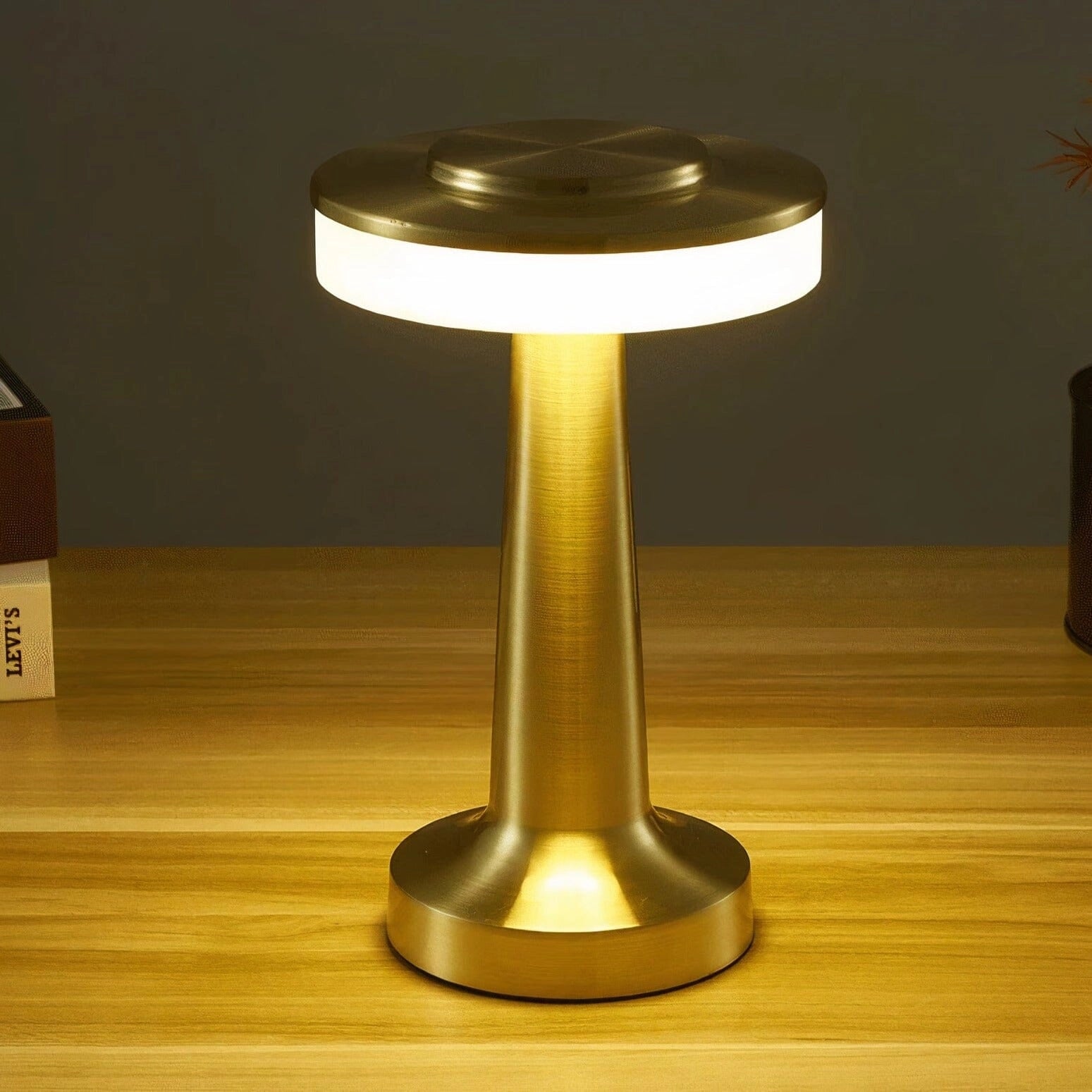 Luxury modern LED desk lamp with a brass finish, featuring a sleek design, wood pedestal base, and a simple circular lampshade, suitable for bedside or office use.
