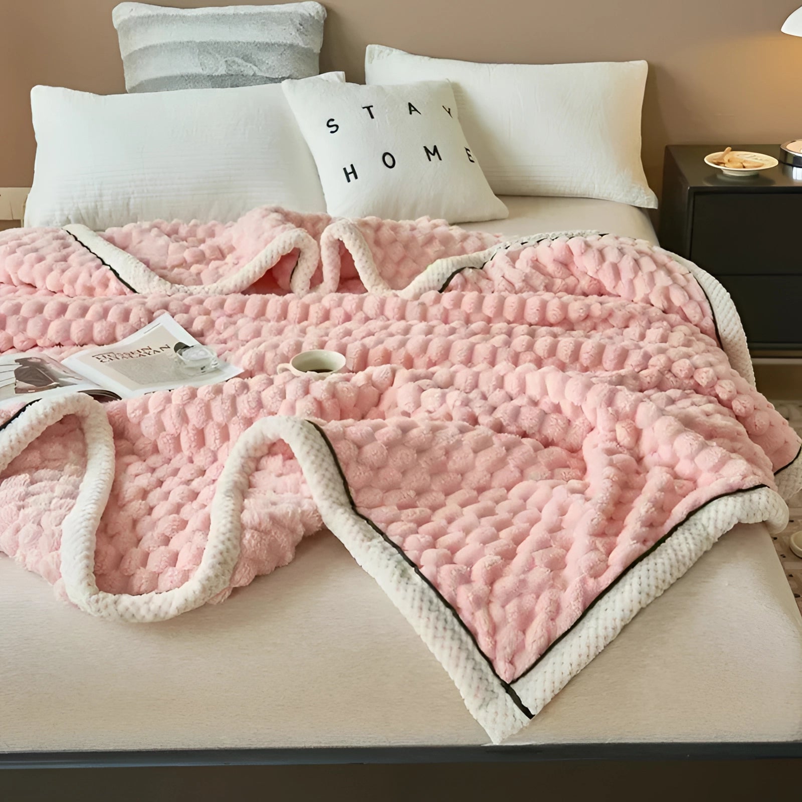 Luxurious pink comforter set featuring a plush textured blanket in a soft magenta hue, elegantly arranged on a bed with white and pink linens, complemented by decorative pillows, providing a cozy and stylish bedroom decor.