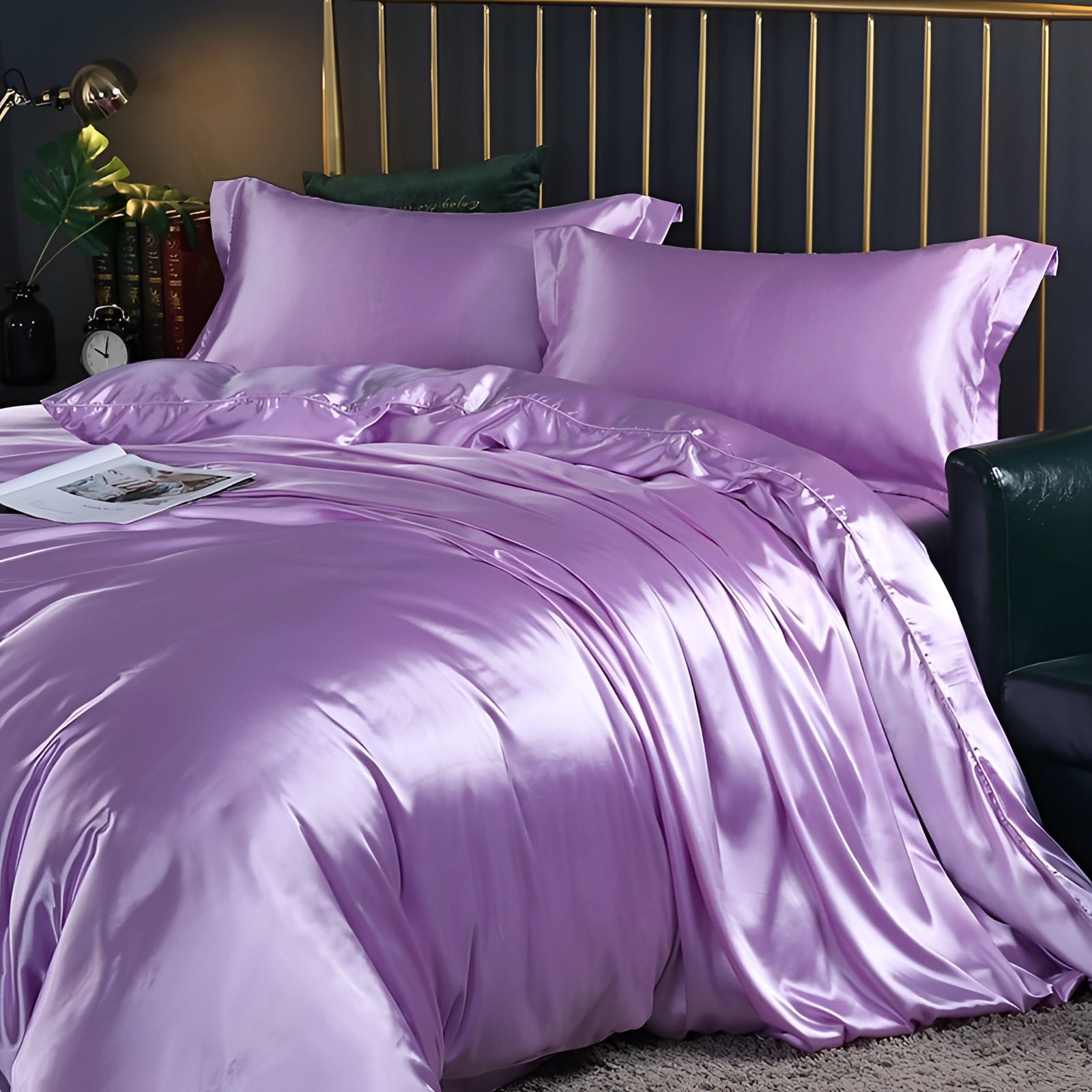 Luxurious purple silk bedding set on a wooden bed frame, featuring a fitted sheet, duvet cover, and pillows in a cozy interior design setting.