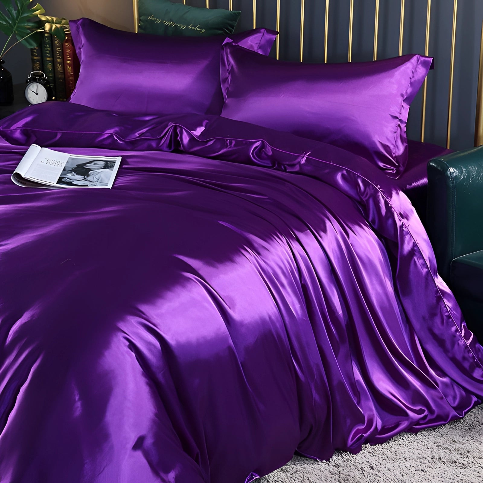Dark lavender luxury silk bedding set with a fitted sheet, displayed on a bed frame. The 4-piece set includes pillowcases and appears soft and elegant, with a rich purple hue that adds a touch of sophistication to the bedroom decor.