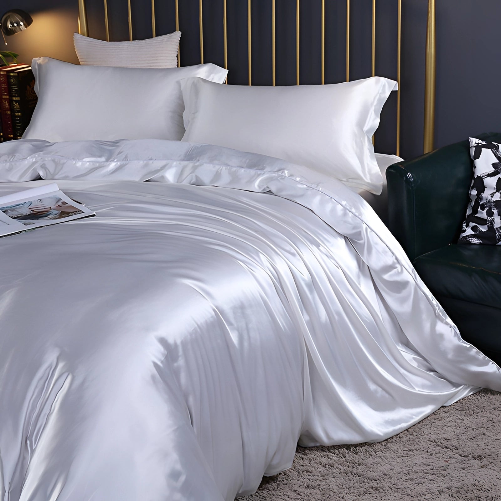 Luxury white silk bedding set displayed on a neatly made bed with matching pillows, situated in a well-lit, stylish bedroom interior with wooden flooring.