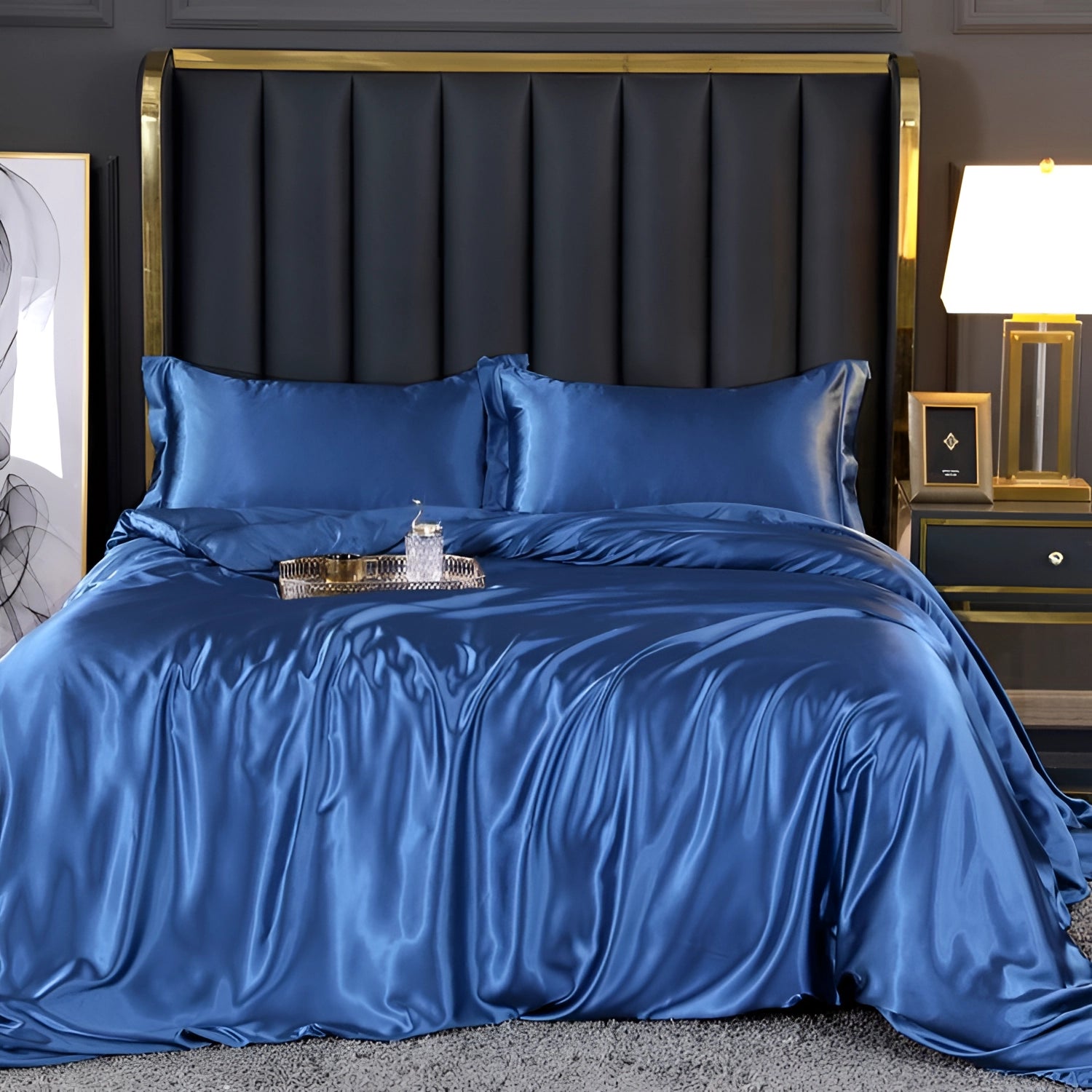 Luxury silk bedding set in cashmere blue displayed on a bed, featuring a 180x200cm fitted sheet, with matching pillowcases and duvet cover, complemented by a wooden bed frame and a nearby lamp for cozy ambiance.