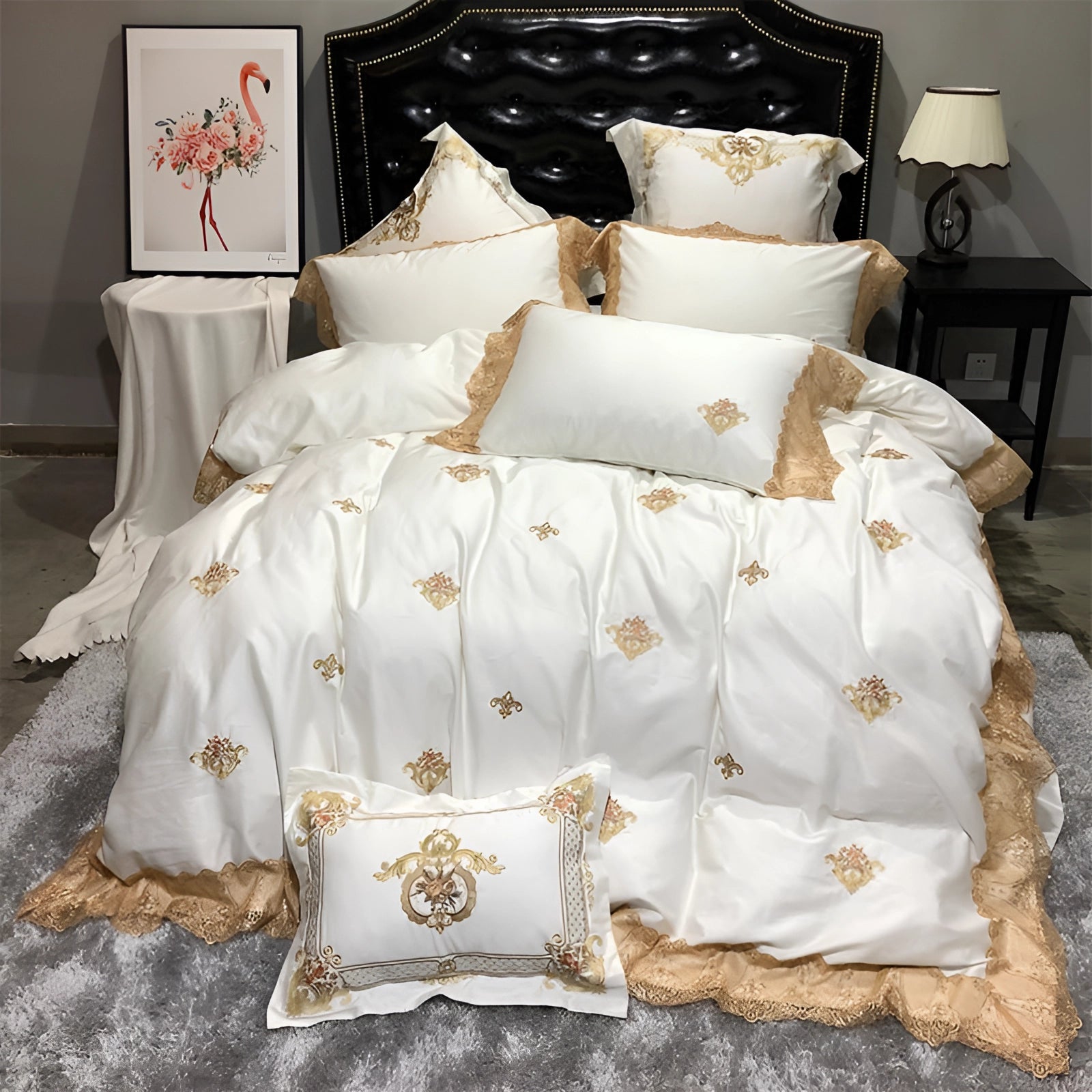 Luxury silk bedding set featuring white duvet and pillowcases with gold embroidery, displayed on a king-size bed, complemented by elegant linens and ambient lighting.