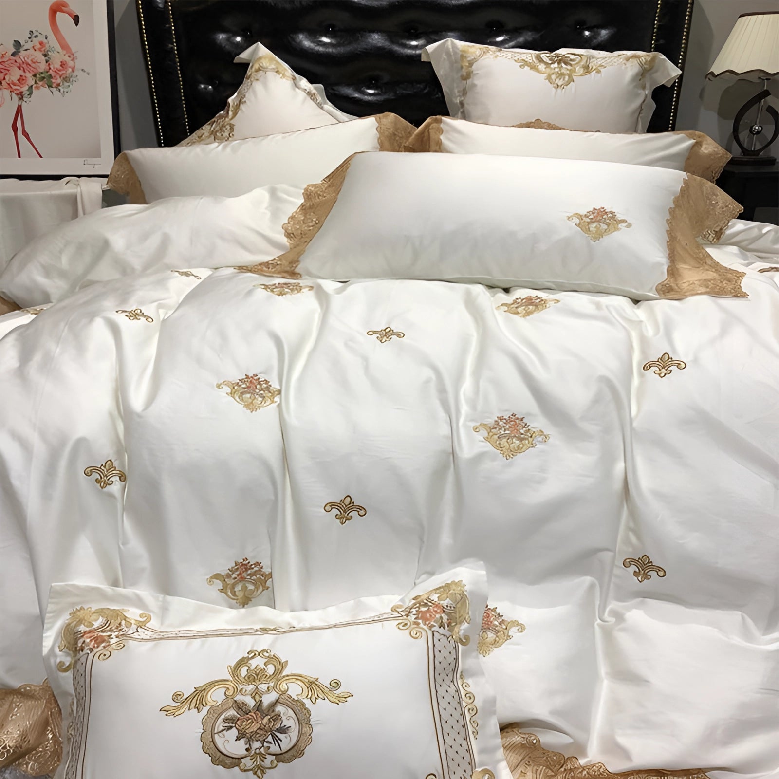 Luxury silk bedding set featuring a white duvet cover with intricate gold embroidery, accompanied by matching pillowcases, displayed on a neatly made bed.