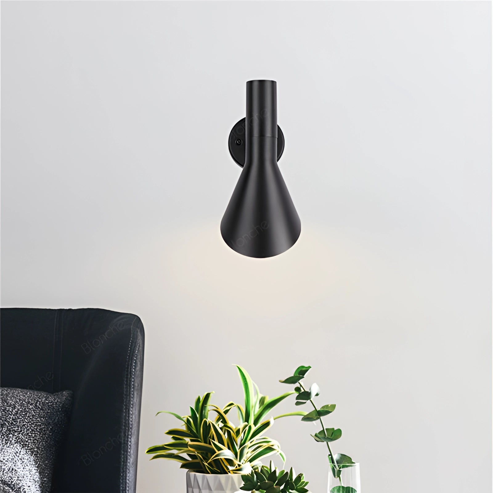 Matte black adjustable LED wall lamp mounted on a wall above a wooden table, with a modern and minimalist design suitable for a bedroom setting.