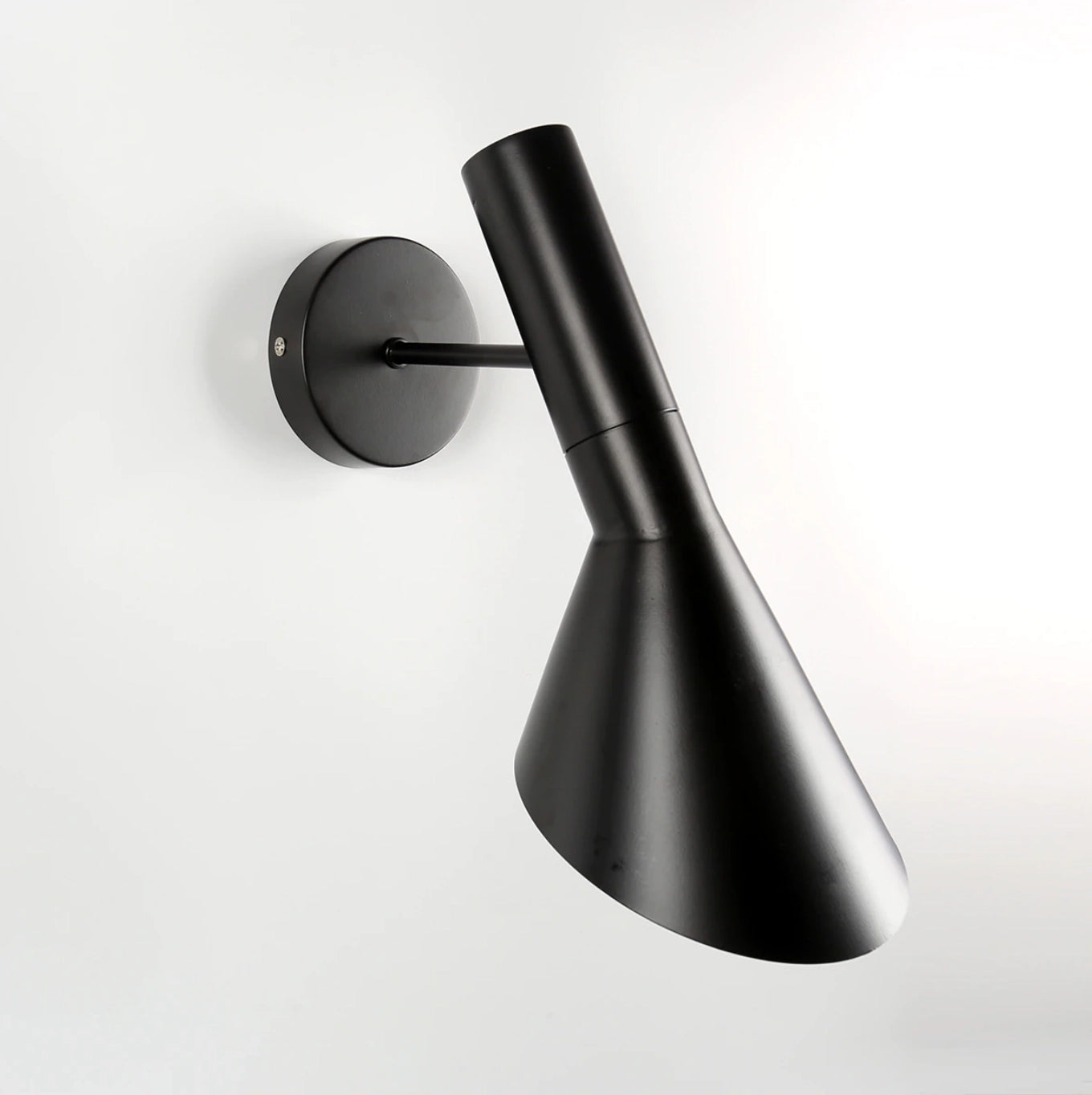 Matte black adjustable LED wall lamp with a modern sconce design, featuring a cylindrical shape and metallic finish, suitable for bedroom decor.