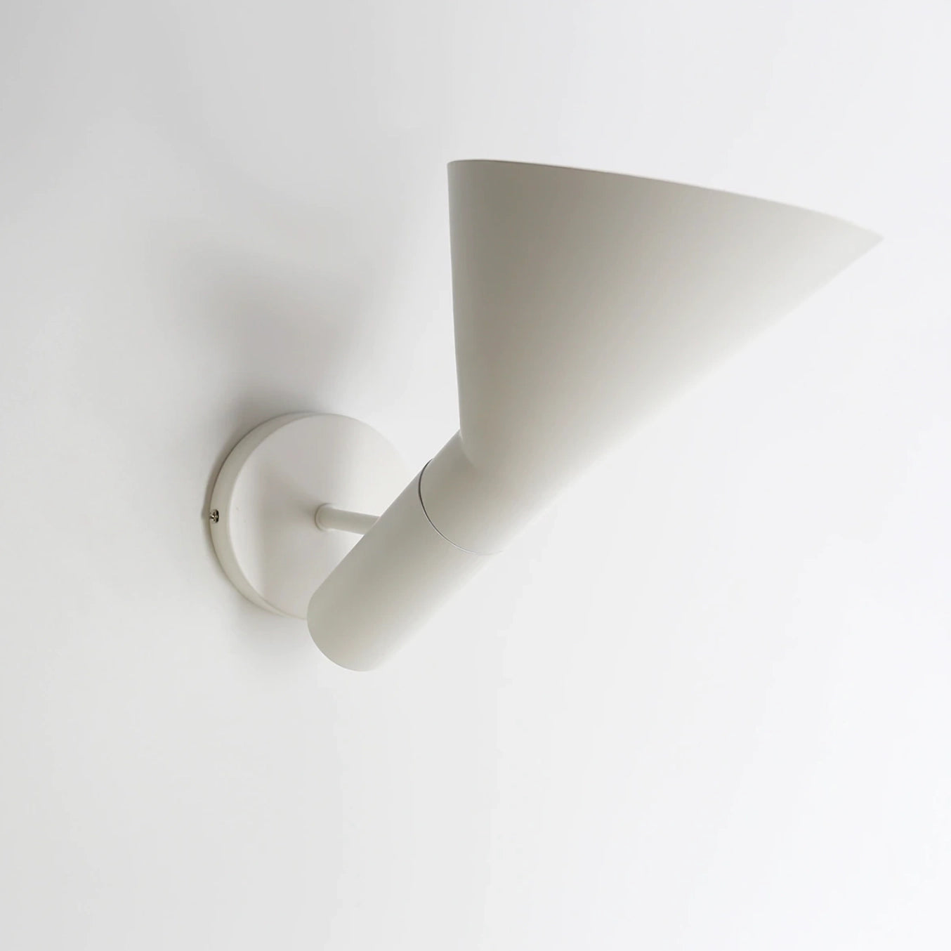 Matte black adjustable LED wall lamp mounted on a wall, displaying a modern design ideal for bedroom lighting.