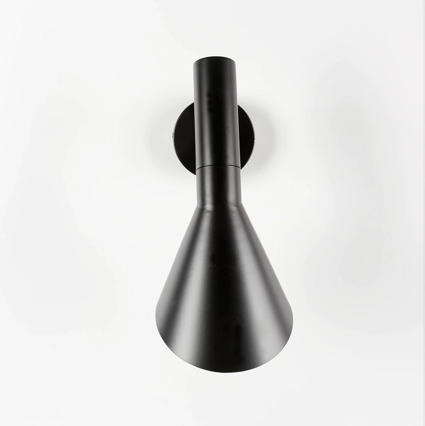 Matte black adjustable LED wall lamp with a modern design, mounted on a wall, featuring a circular metal base and sleek arm.