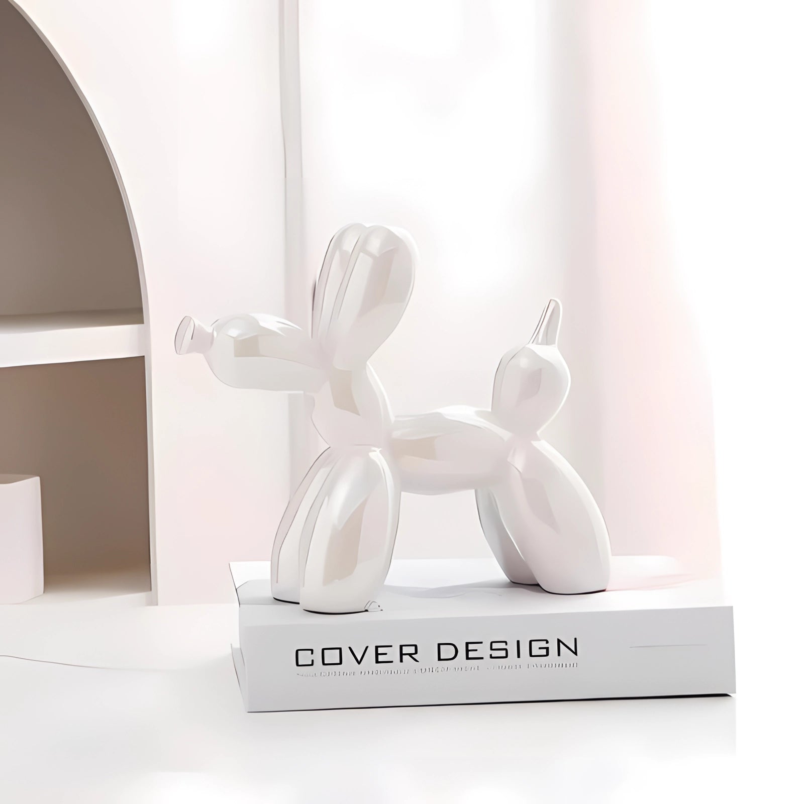 White metallic balloon dog sculpture in a modern art decor setting, featuring luxury design and artistic appeal, placed on a wooden surface.