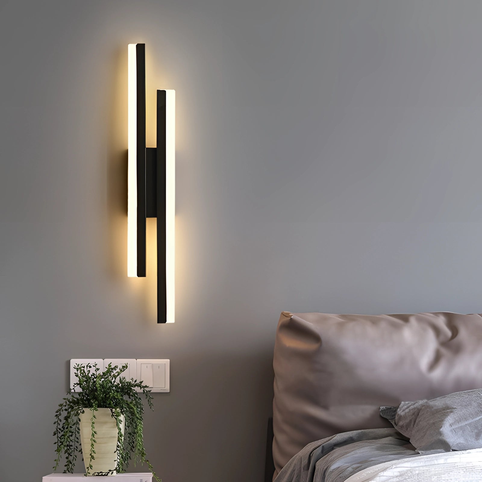 Minimalist black and white vertical line art displayed on a wall in a modern living room setting, featuring a cozy couch, wooden elements, soft lighting, and a small plant in a flowerpot for decor.