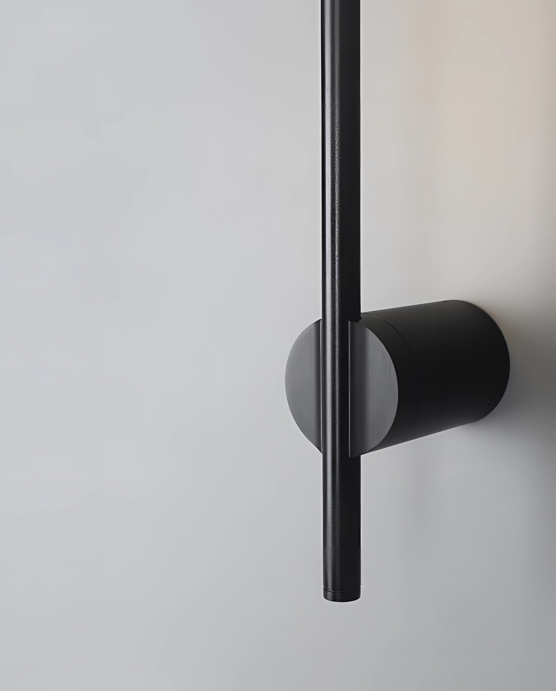 Minimalist LED wall sconce with sleek vertical light design, mounted on a modern home interior wall.