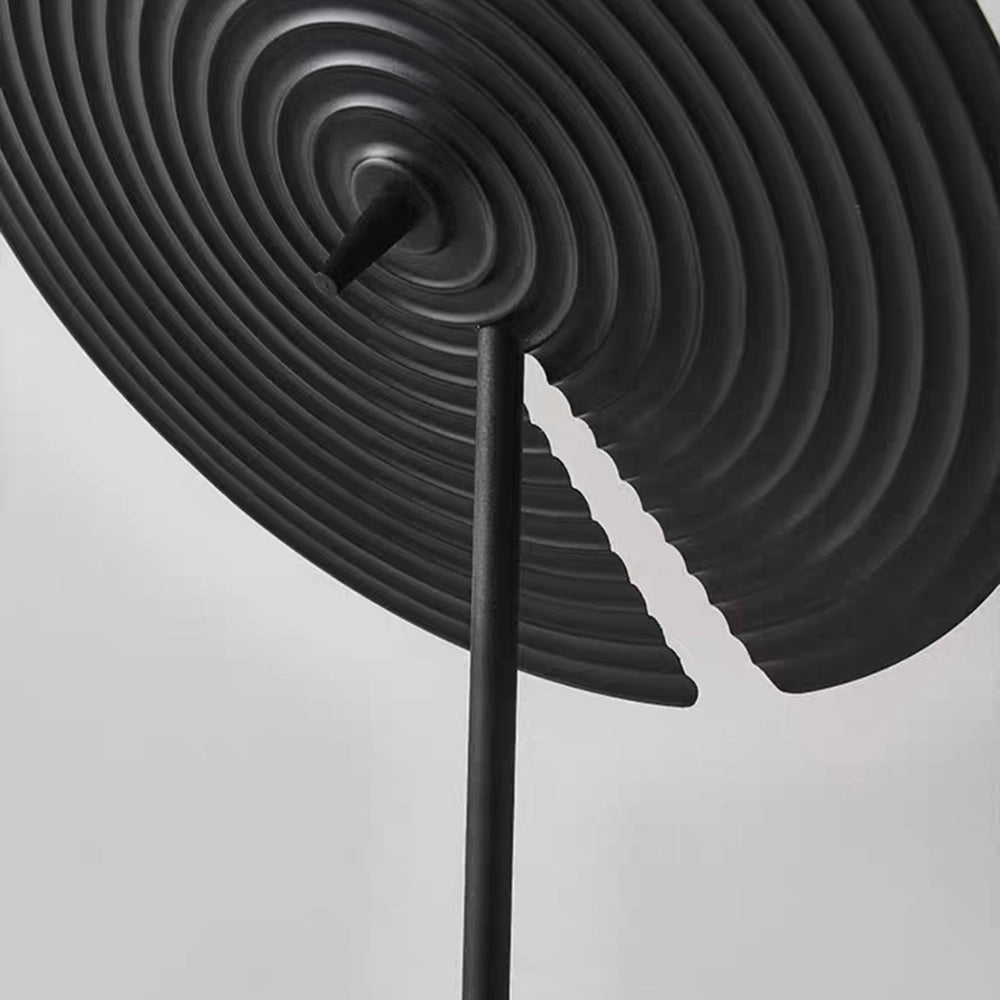 A minimalist matte black floor lamp with an adjustable lighting feature, showcasing a sleek and modern design with a monochrome finish.