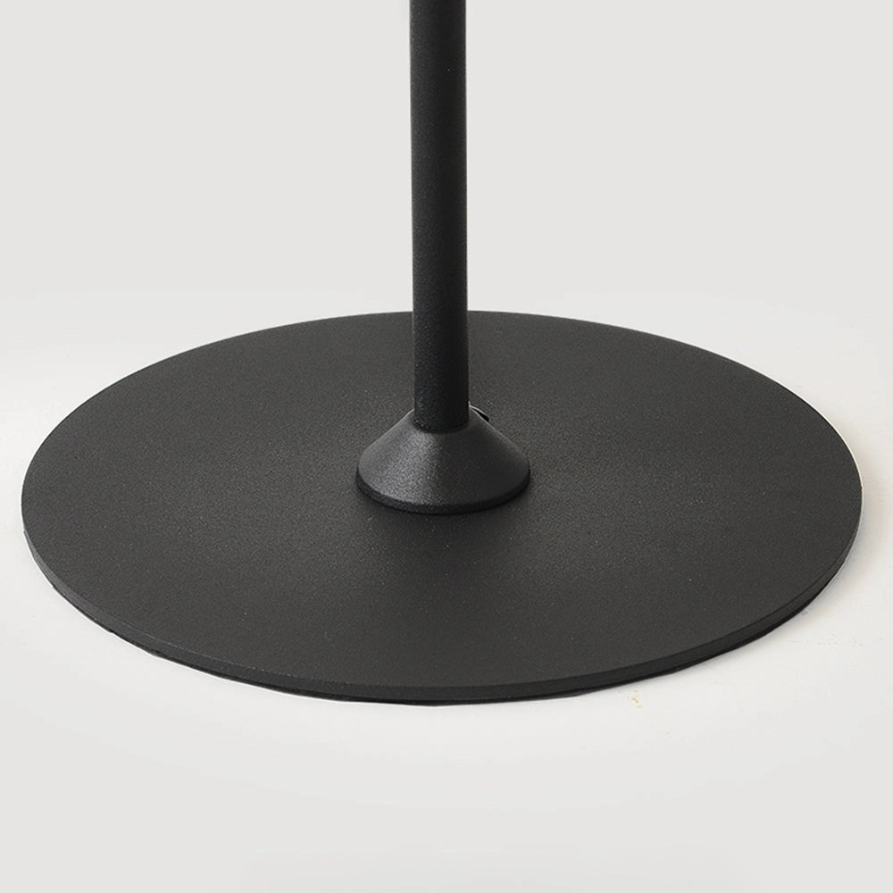 Minimalist matte black floor lamp made of composite materials, featuring a sleek circular base and adjustable rectangle-shaped lighting component, constructed from aluminum metal, showcased in a balanced and symmetrical design against a modern flooring backdrop.