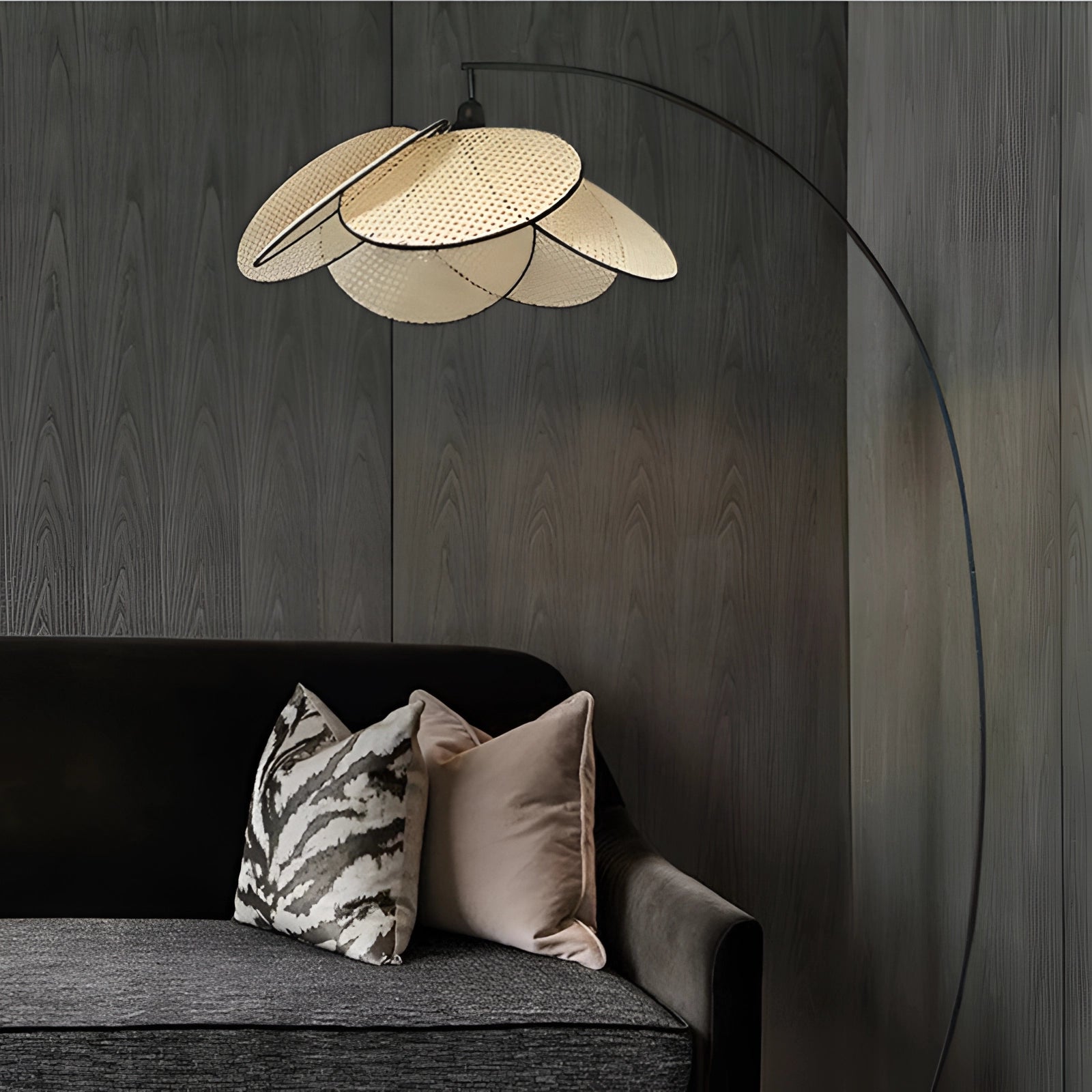 Modern adjustable arched floor lamp with a minimalist design, featuring a black arc and a grey textile shade, standing in a stylish interior with wood and comfort elements.