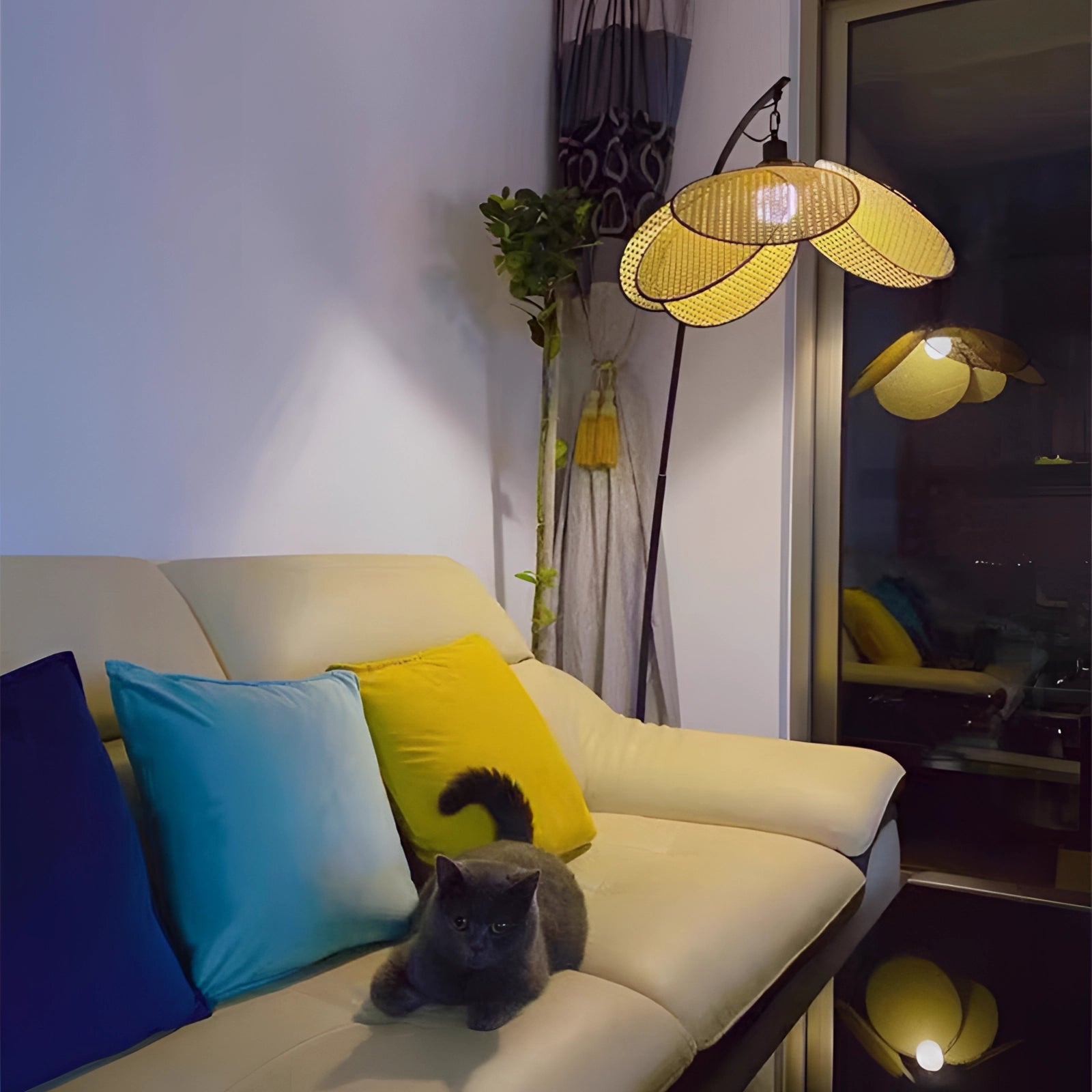 Modern adjustable arched floor lamp in a minimalist design, illuminating a stylish living room with a yellow couch, wooden table, and green potted plant.