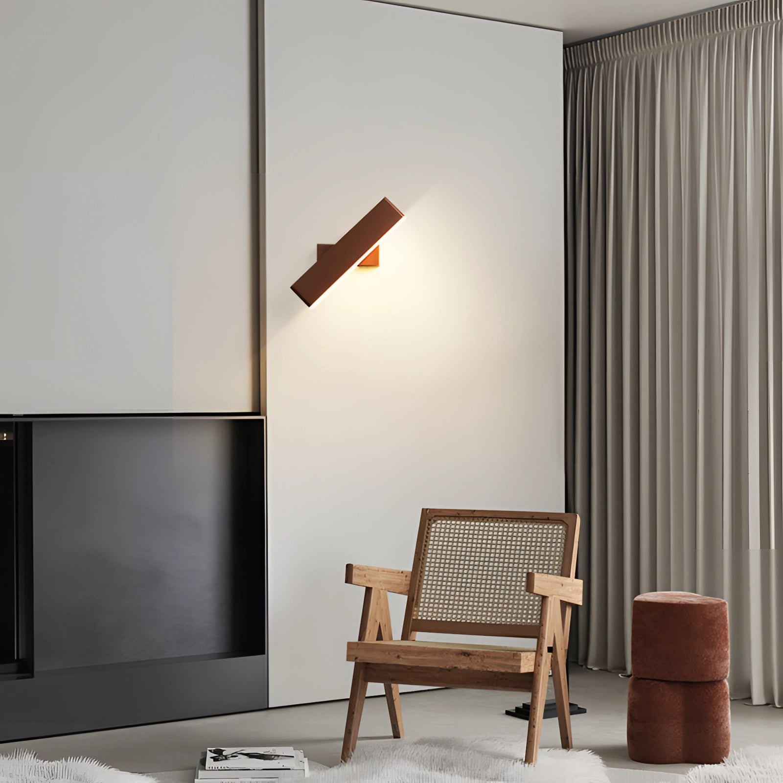 Modern black LED wall sconce with a minimalist geometric design mounted on a wooden interior wall, complementing sleek furniture and hardwood flooring.