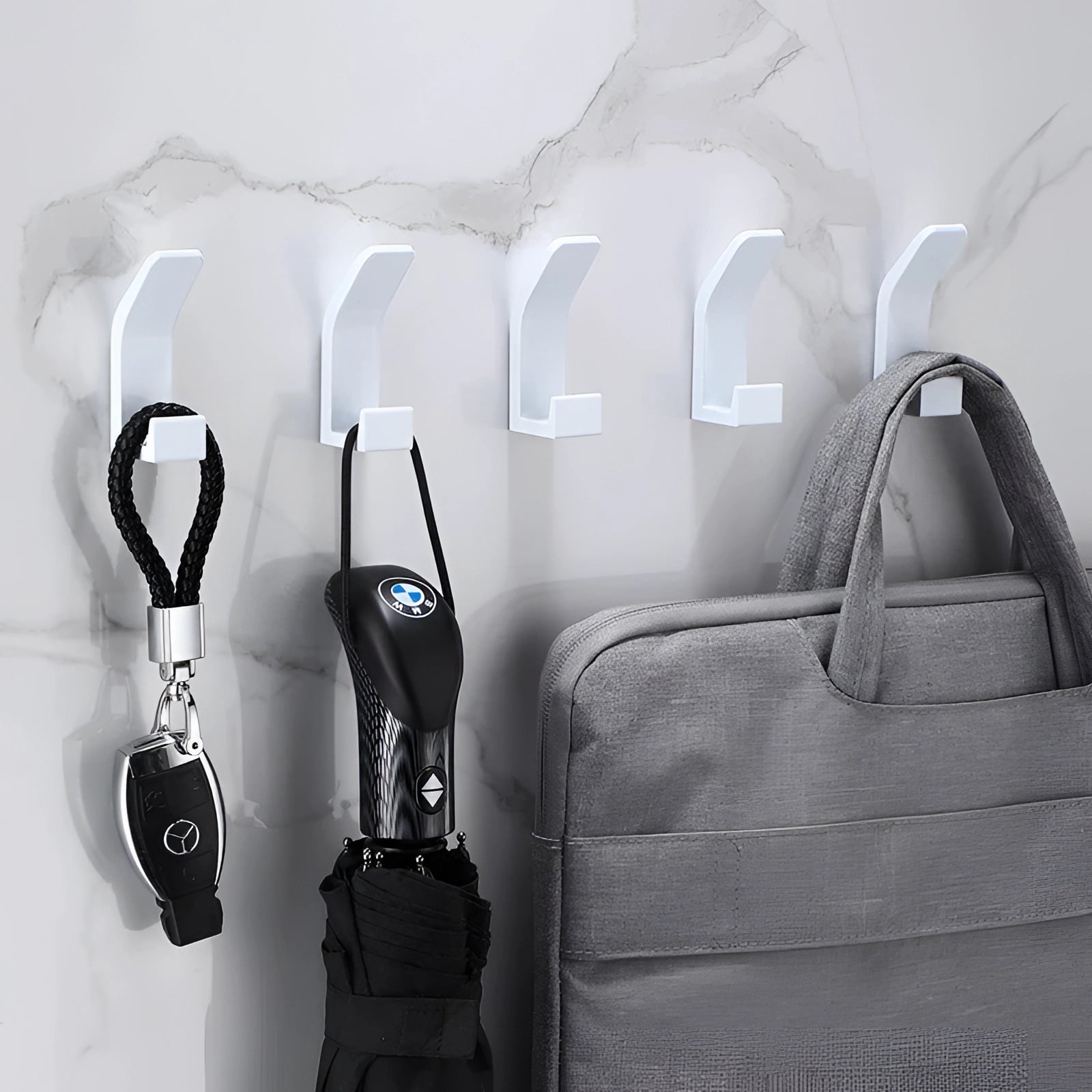 A set of five modern black metal wall hooks designed in a minimalist and stylish fashion, perfect for contemporary home decor. Each hook is sleek and has a white finish, emphasizing simplicity and elegance.