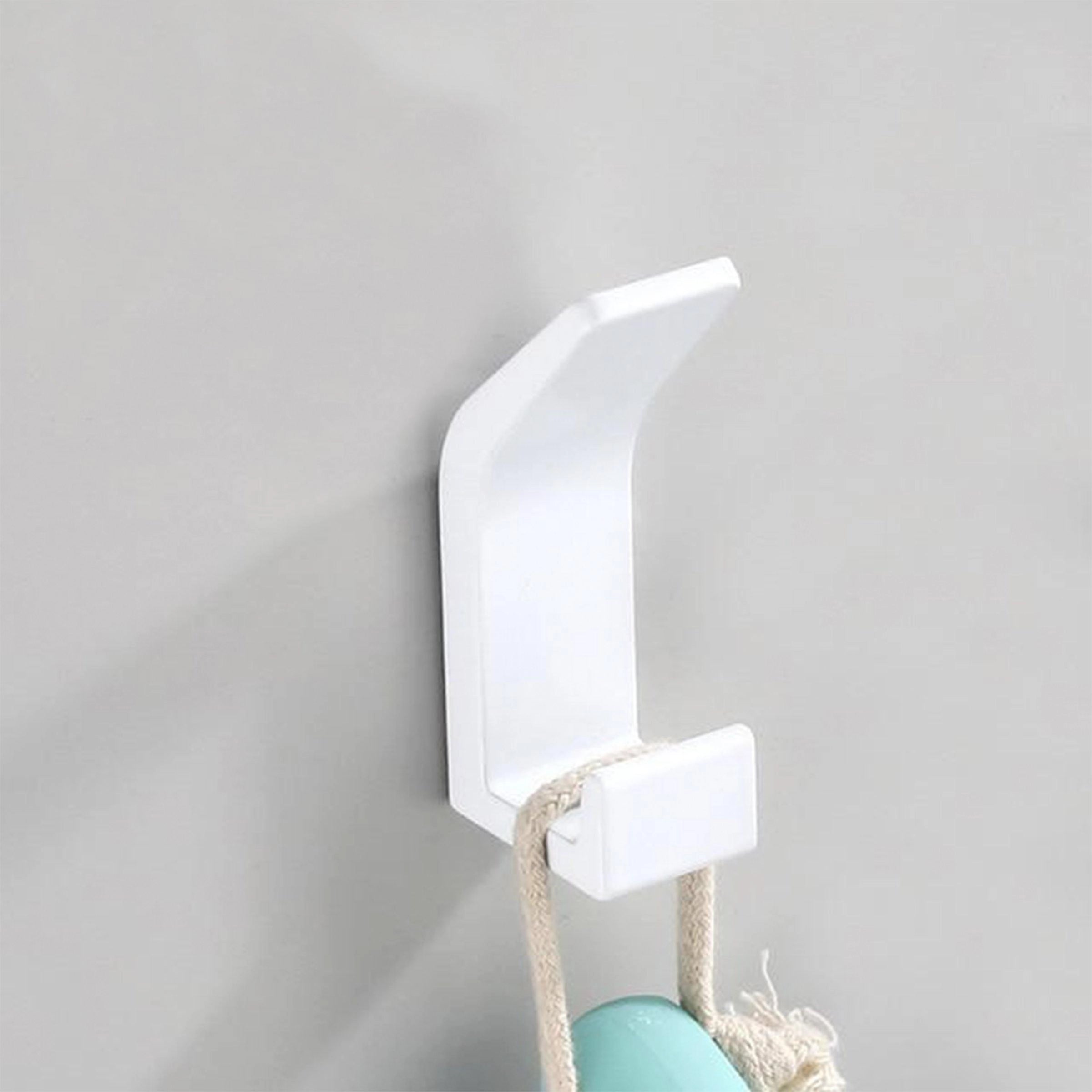 Minimalist white metal wall hook for home decor, mounted on a wooden surface, with a modern design and sleek finish.