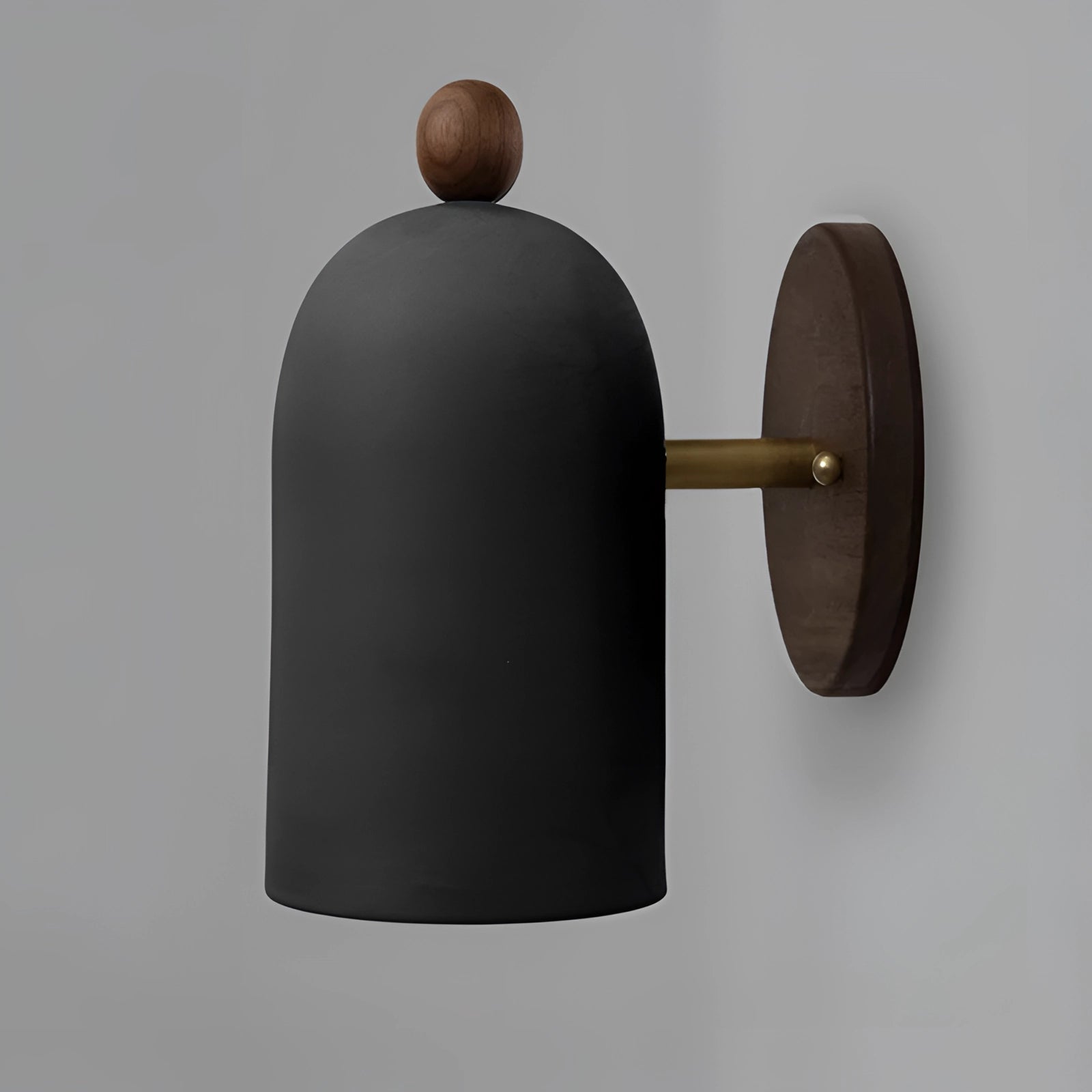 Modern black wall sconce with a minimalist industrial design, featuring a cylindrical metal lamp mounted on a wooden base.