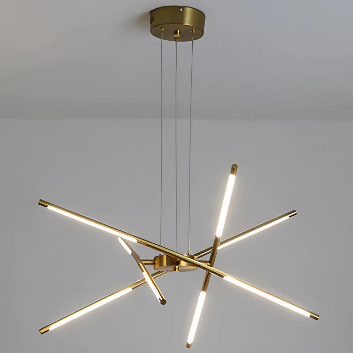 Modern brass LED chandelier with circular light fixture, elegantly hanging from the ceiling, designed for luxury dining room decor.