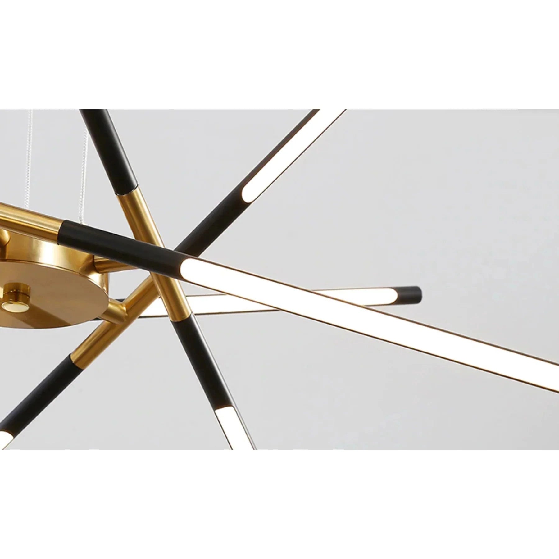Modern brass LED chandelier with circular metal design hanging from the ceiling in a luxury dining room.
