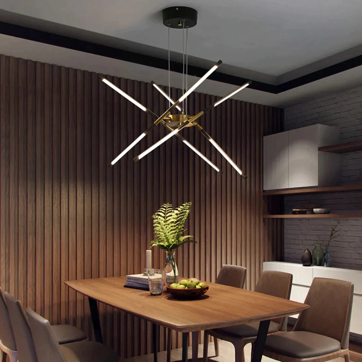 Modern brass LED chandelier hanging above a dining table with wooden chairs in a luxury dining room setting.