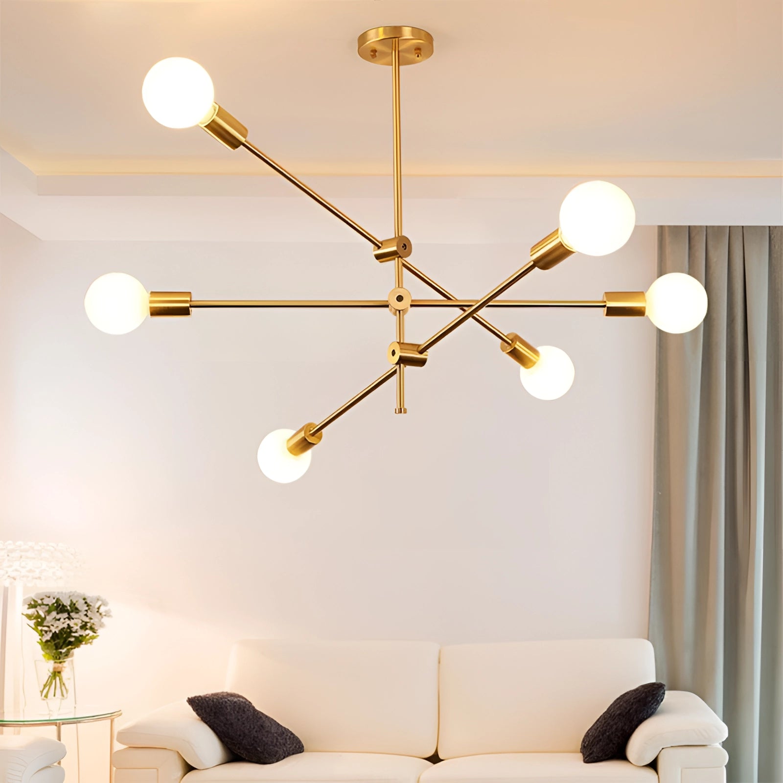 Modern brass Sputnik chandelier with adjustable geometric design, featuring multiple light branches in a mid-century style, illuminating a contemporary interior space with white walls and wood accents.
