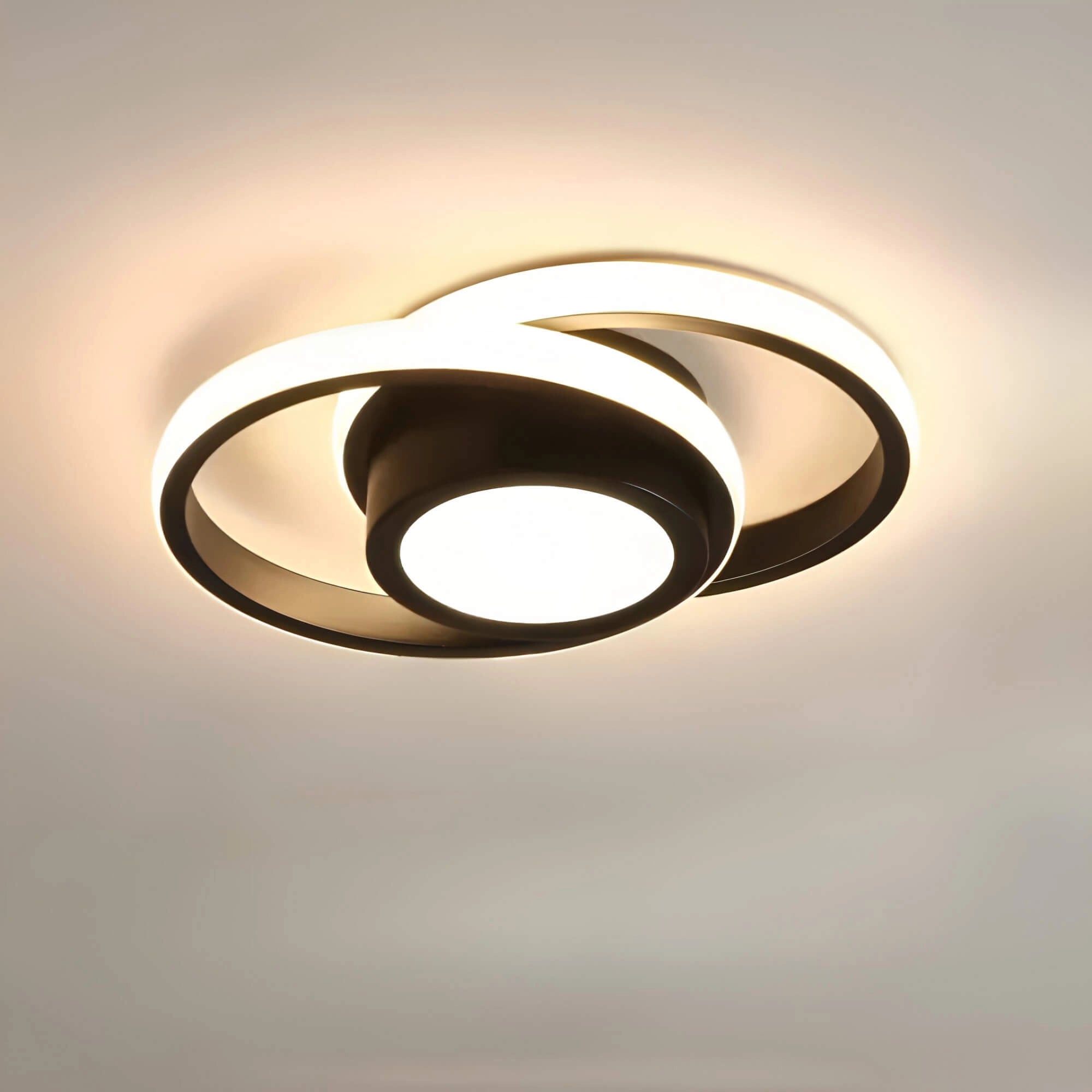 Modern circular LED ceiling light with a sleek black frame, featuring a minimalist design and energy-efficient illumination, mounted on a wooden ceiling.