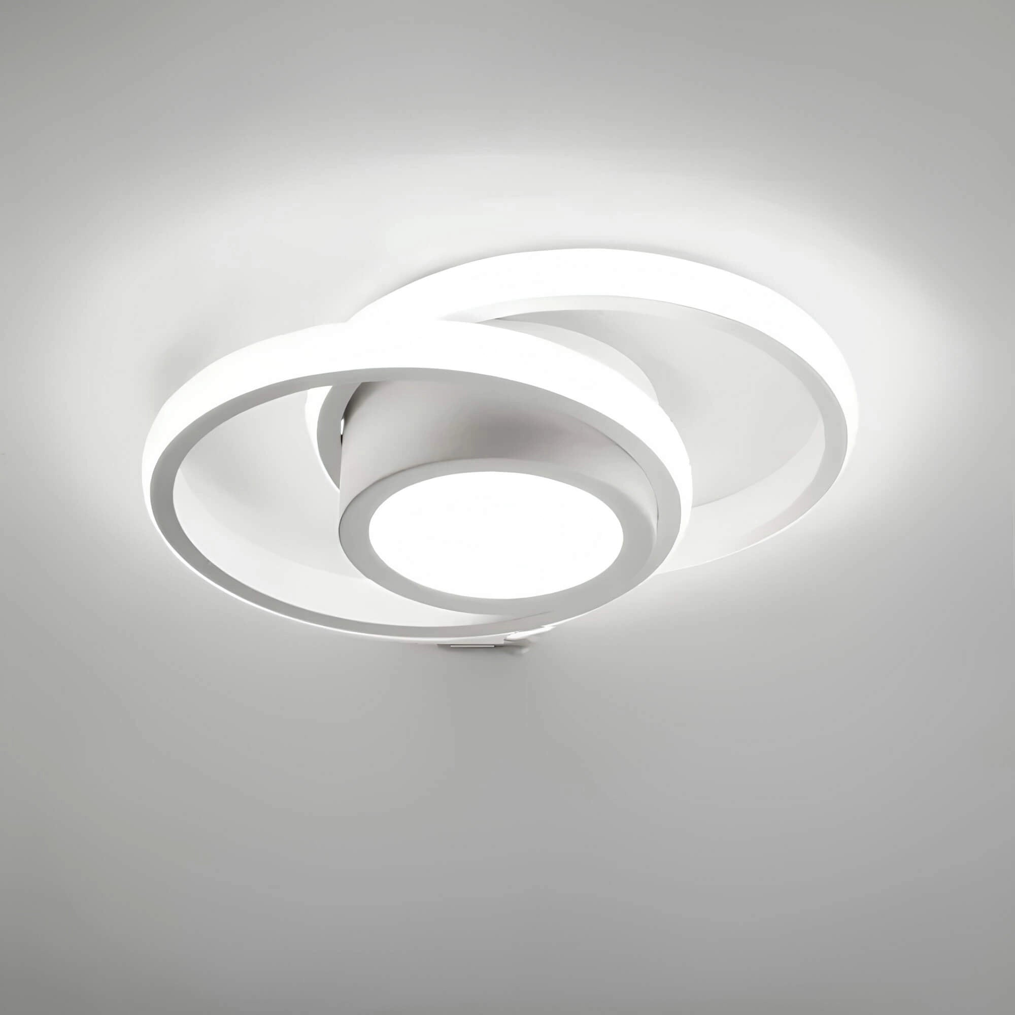 Modern circular LED ceiling light in a round white design, featuring an energy-efficient and minimalist aesthetic. The light fixture is mounted on the ceiling and is crafted from metal, showcasing a sleek monochrome appearance.