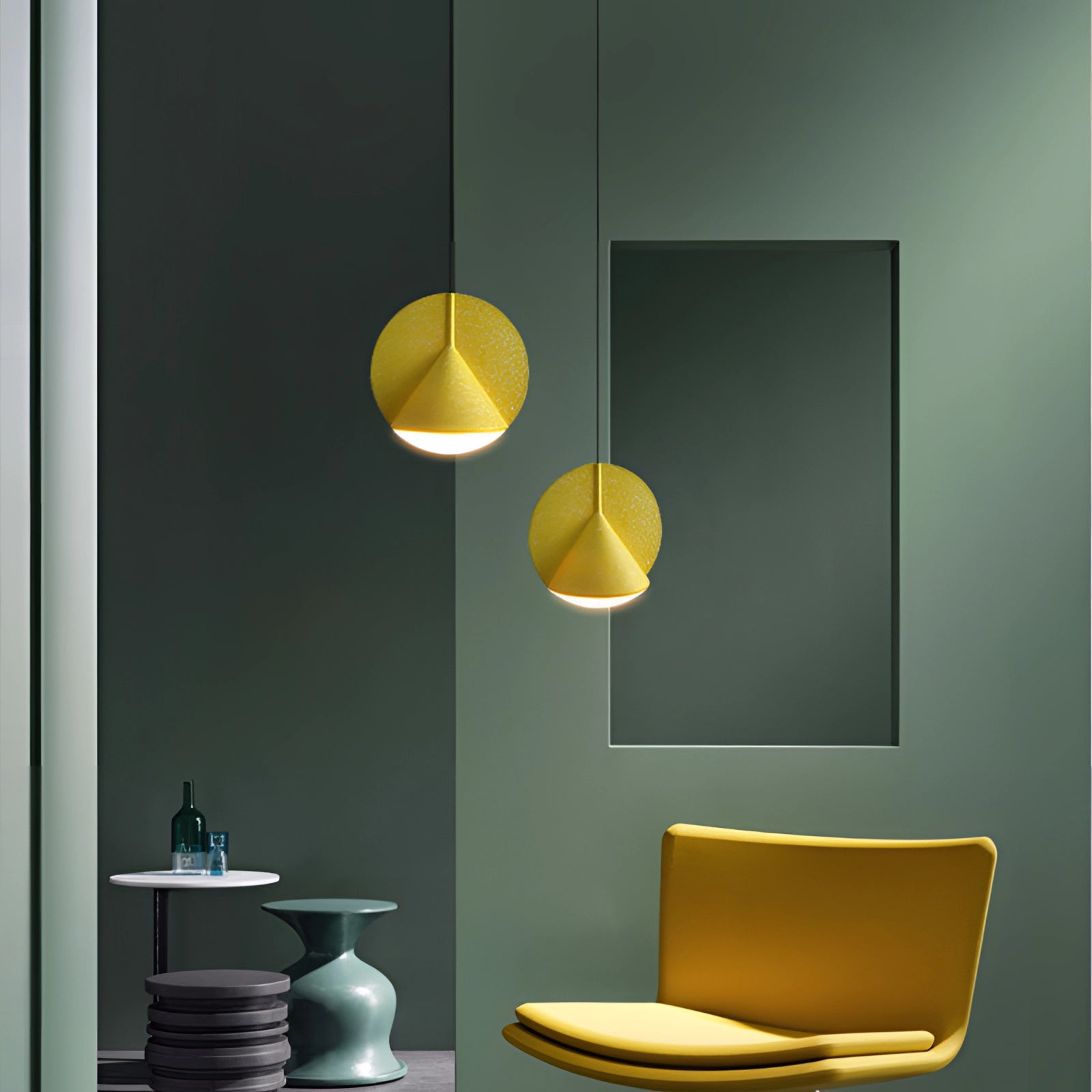 Modern colorful fabric pendant lights hanging in a contemporary interior setting with yellow accents and rectangular shapes on the wall.