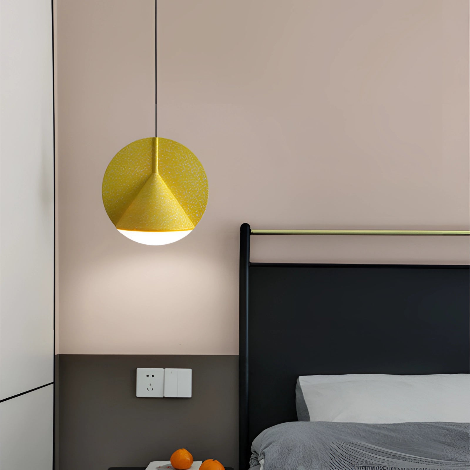Modern yellow fabric pendant light hanging in a contemporary interior setting, with wooden accents and tableware in the background.