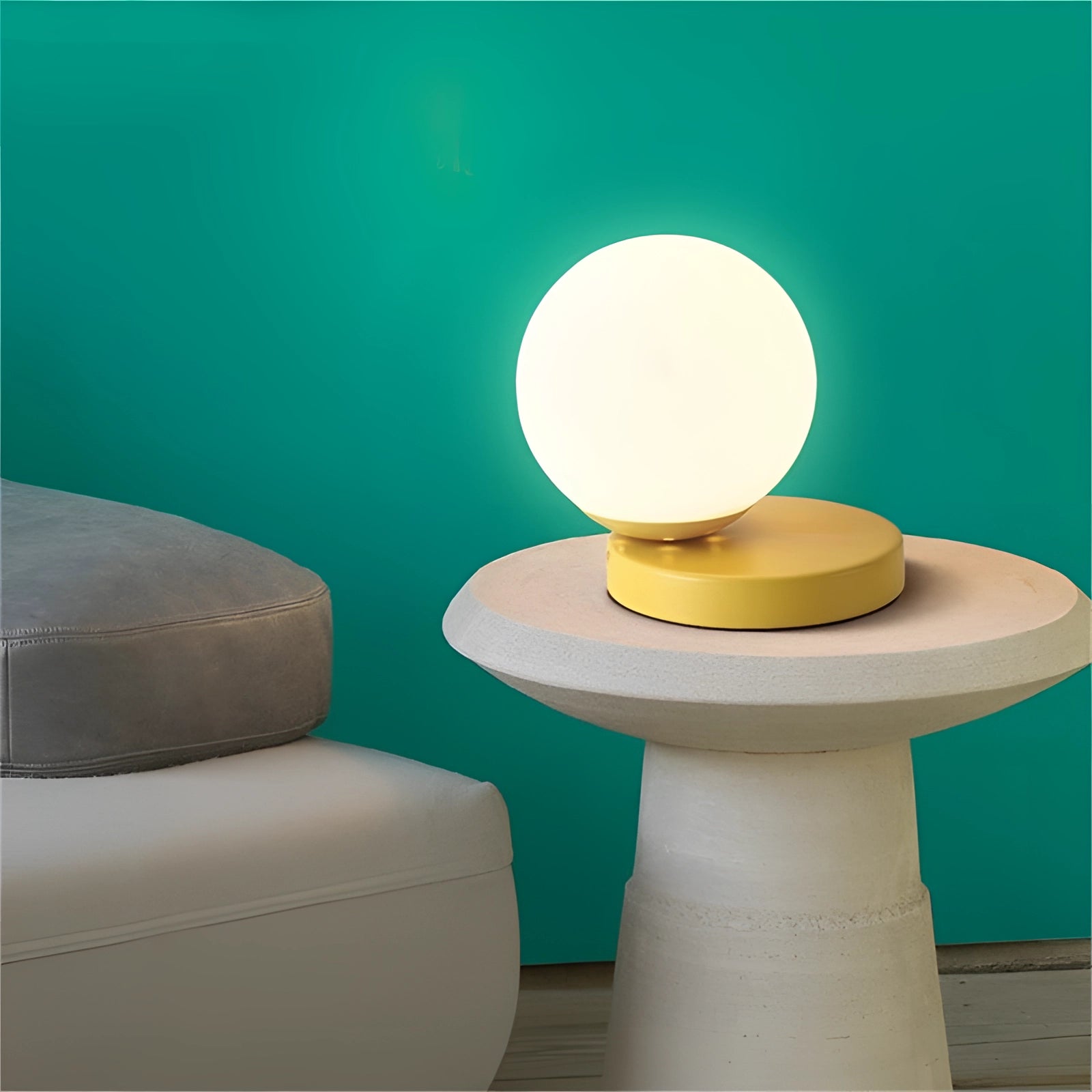 Modern designer orb lamp with an LED globe and metallic base, resting on a wooden table. The lamp features a circular design with a sleek, artistic look, complemented by a soft, ambient glow.