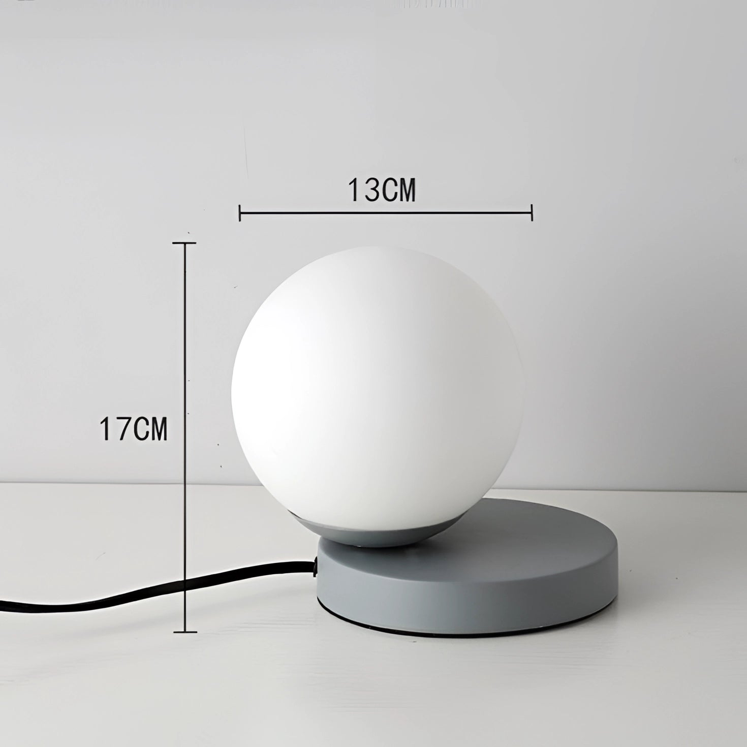 A modern designer orb lamp featuring a sleek LED globe with a metallic base, showcasing a contemporary design in a gray finish.