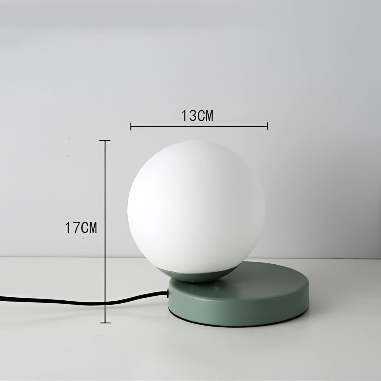 Modern designer orb lamp featuring a green LED globe with a metallic base, showcasing a sleek contemporary design.