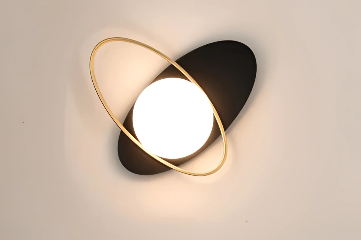 Modern dual globe brass wall sconces with a minimalistic design, featuring two spherical glass shades attached to a sleek brass fixture. The sconces are mounted on a wooden surface and emit a warm glow, enhancing the contemporary decor.
