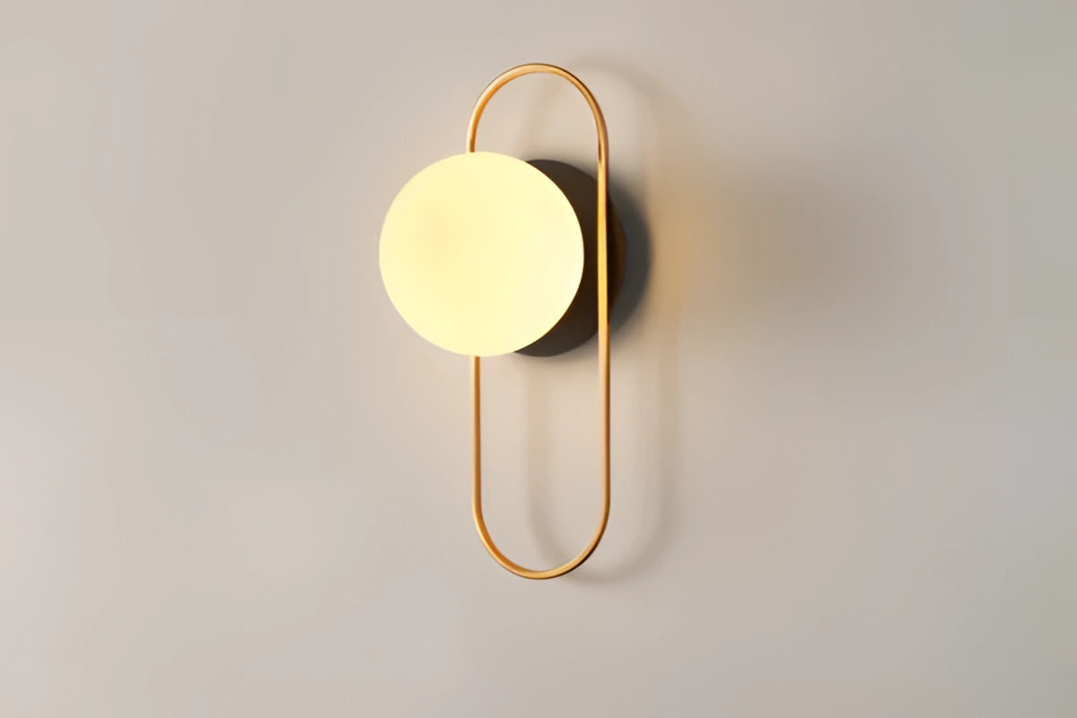 Modern dual globe brass wall sconces featuring a minimalistic design with spherical glass shades and a sleek metal base, mounted on a rectangular backplate, ideal for contemporary lighting decor.