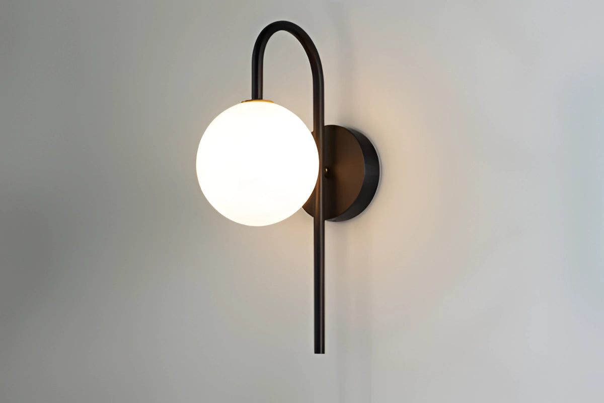 Modern dual globe brass wall sconces mounted on a wooden background, featuring a minimalistic design with circular and rectangular elements, and a warm brass finish for elegant lighting decor.