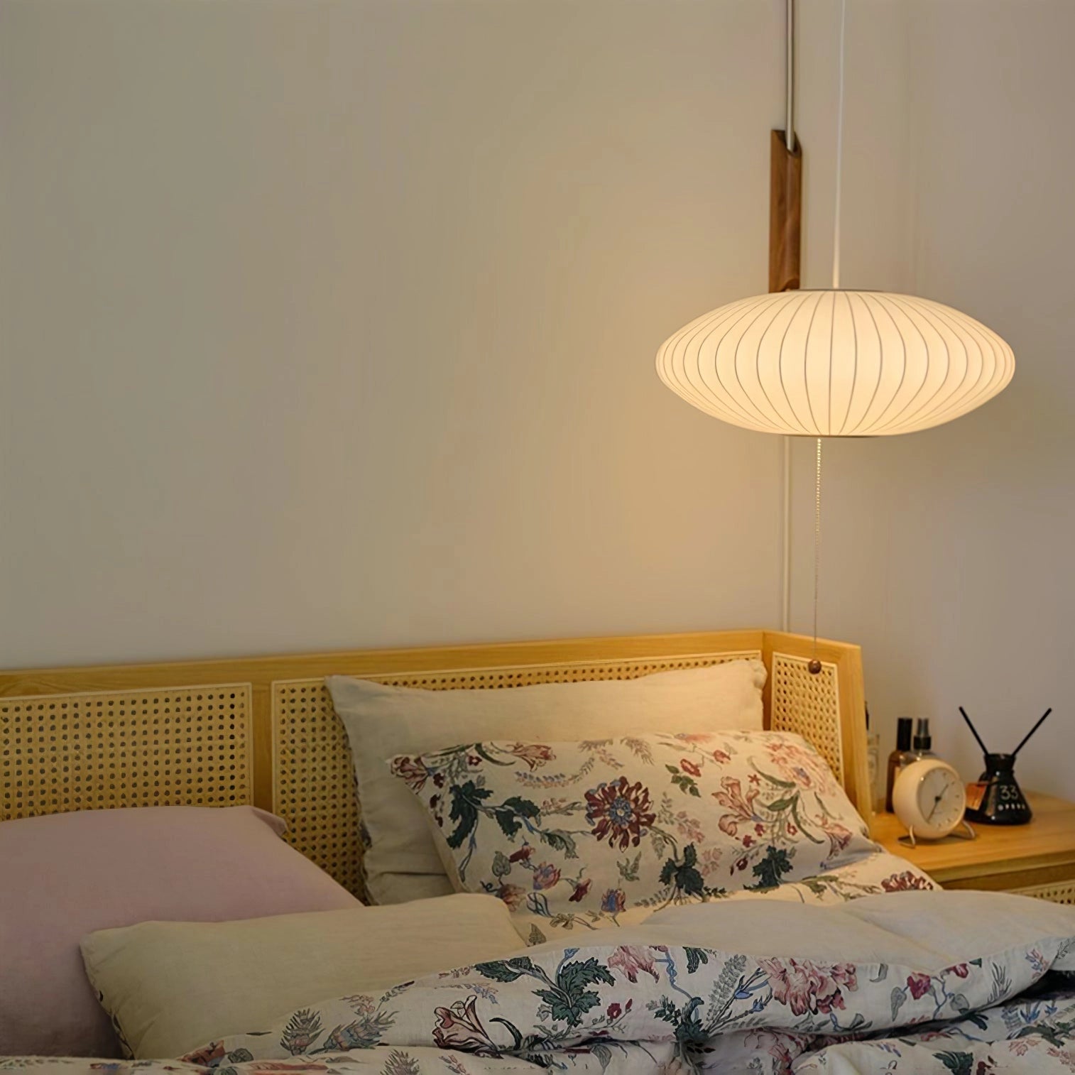 Modern floor lamp with a minimalist design featuring adjustable brass and wood accents, positioned on a floor with a visible lampshade, complementing a cozy interior space.