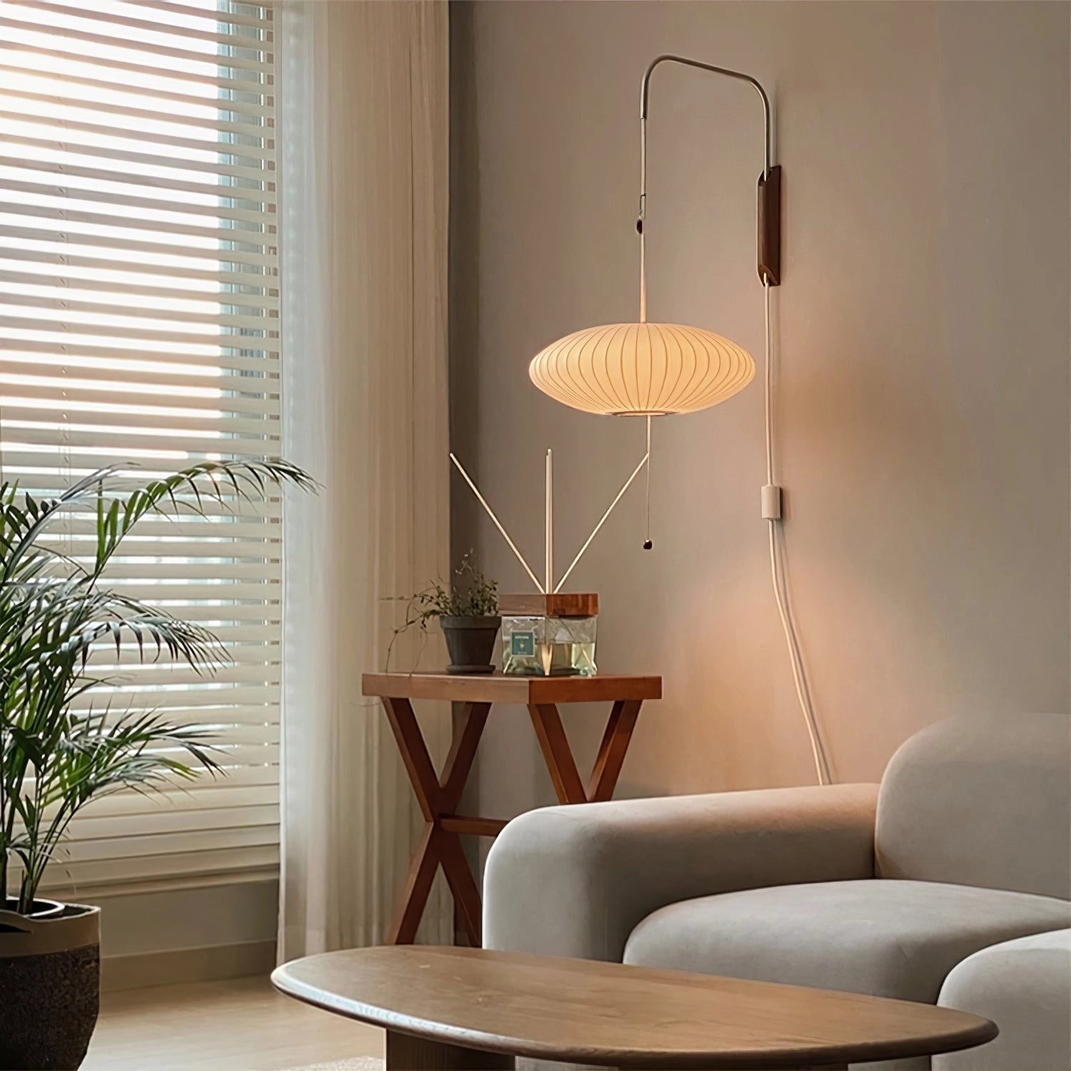 A modern floor lamp featuring a minimalist design with adjustable brass and wood accents, placed in an interior setting alongside a wooden table and houseplants near a window.