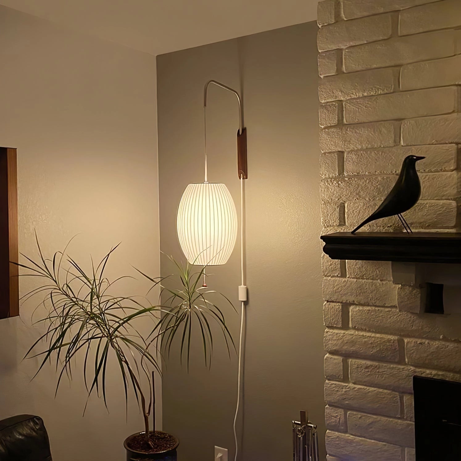 Modern floor lamp with minimalist design featuring adjustable brass and wood accents, set in a stylish interior space with complementing decor elements like a picture frame and soft lighting.