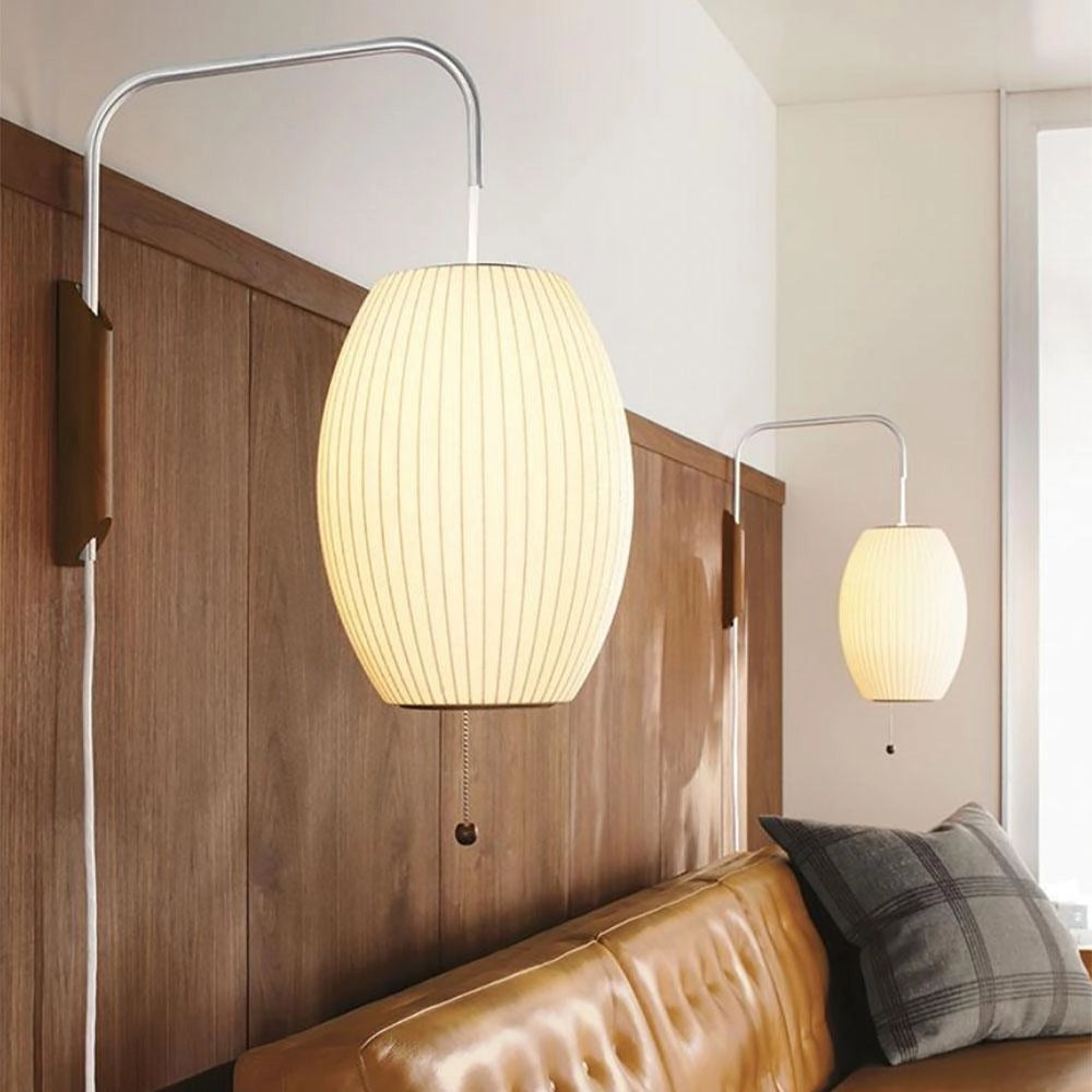 Modern floor lamp with minimalist design featuring adjustable brass and wood accents, situated in an interior space.