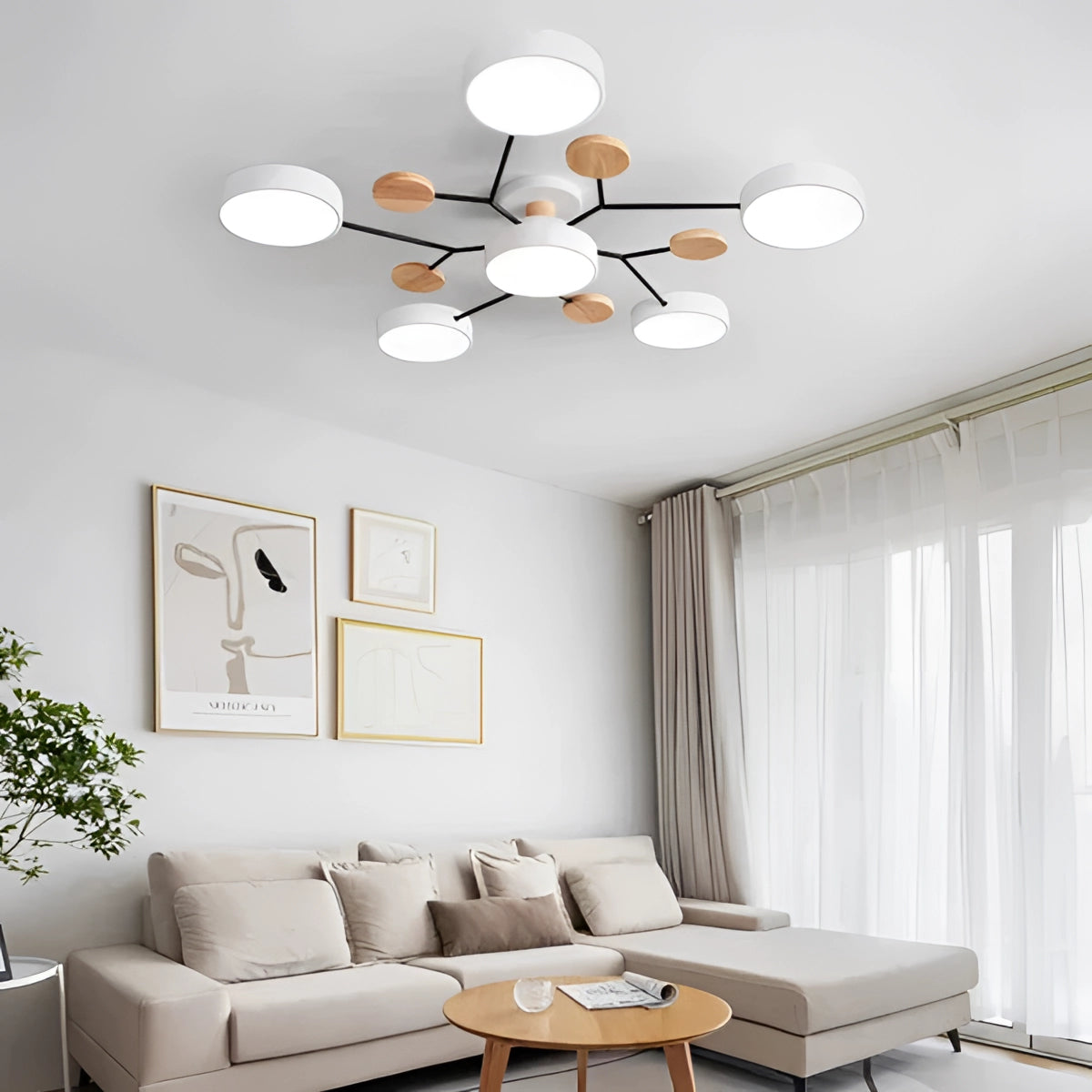 Modern geometric chandelier in matte black and wood with multiple bulbs, hanging in a stylish interior setting featuring a white couch, orange accents, a plant, and a table, illuminated with natural daylight.