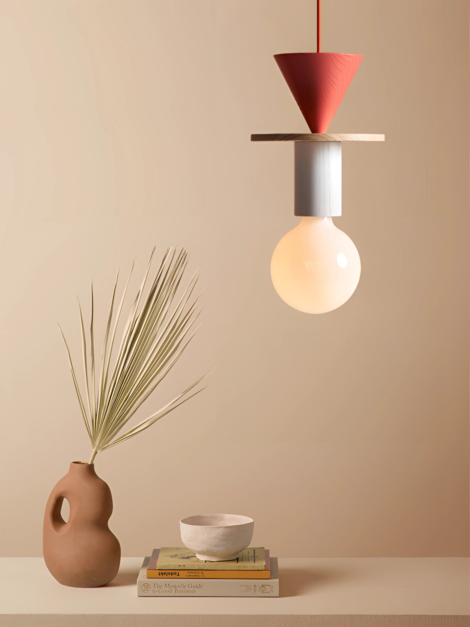 Modern geometric LED pendant light with colorful wood blocks, hanging above a stylish flowerpot with a houseplant, in a contemporary interior design setting.